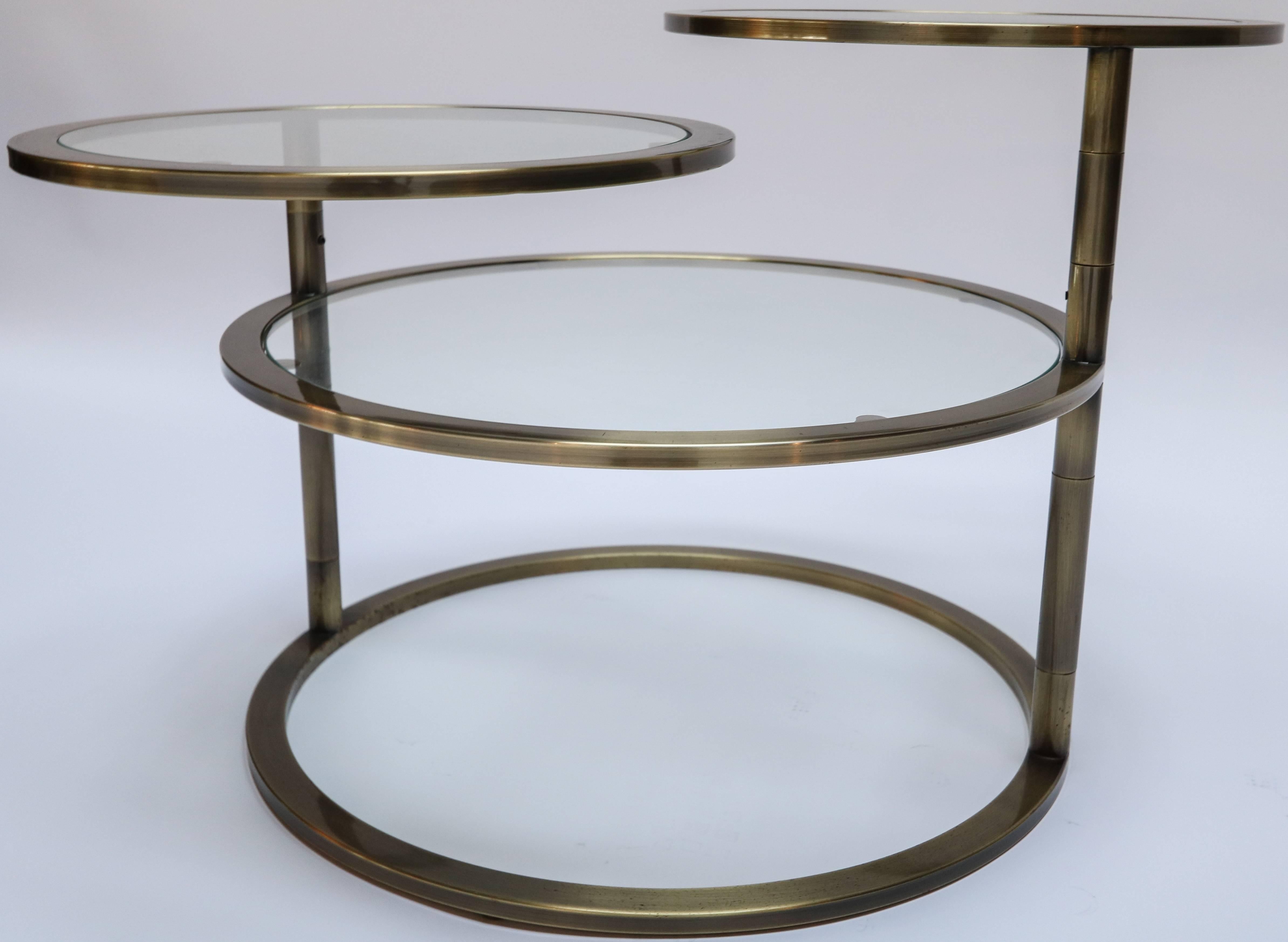 Three-tiered brass coffee or side table with glass shelves. The top two shelves rotate 360 degrees.

Measurements with table open: 22