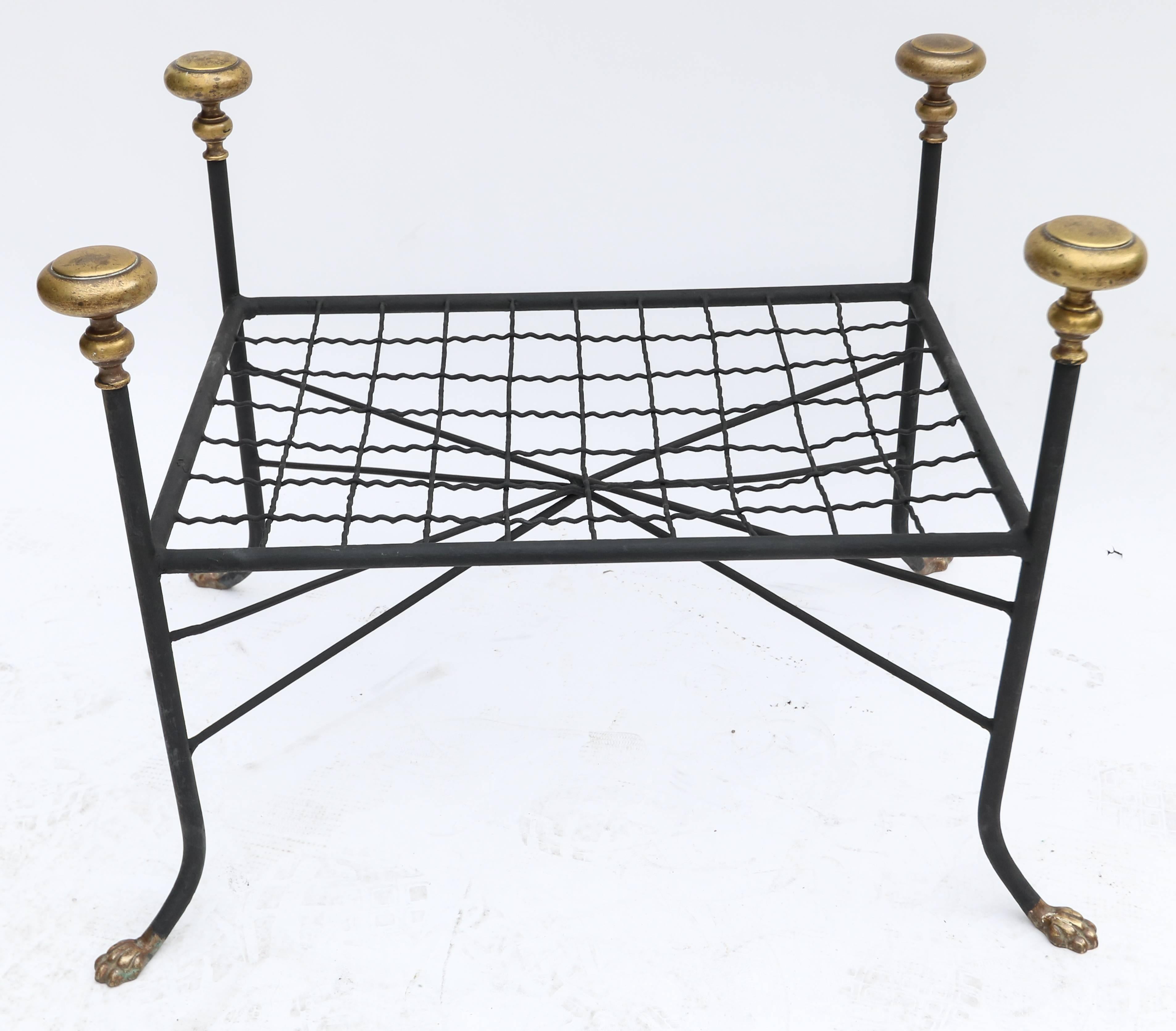 Black metal bench or stool with decorative brass finials and claw feet.