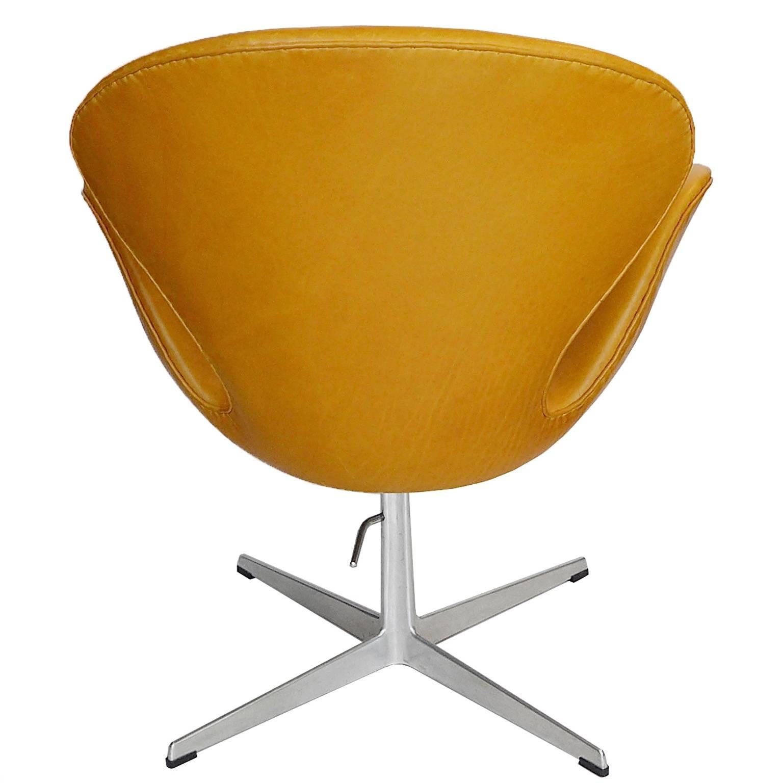 This is a rare golden tan leather adjustable swan chair. It is a great chair. This variation was manufactured by Fritz Hansen for a very short time. The seat adjusts from 16.5”-20”. It can adjust in height from the standard swan lounge height to a
