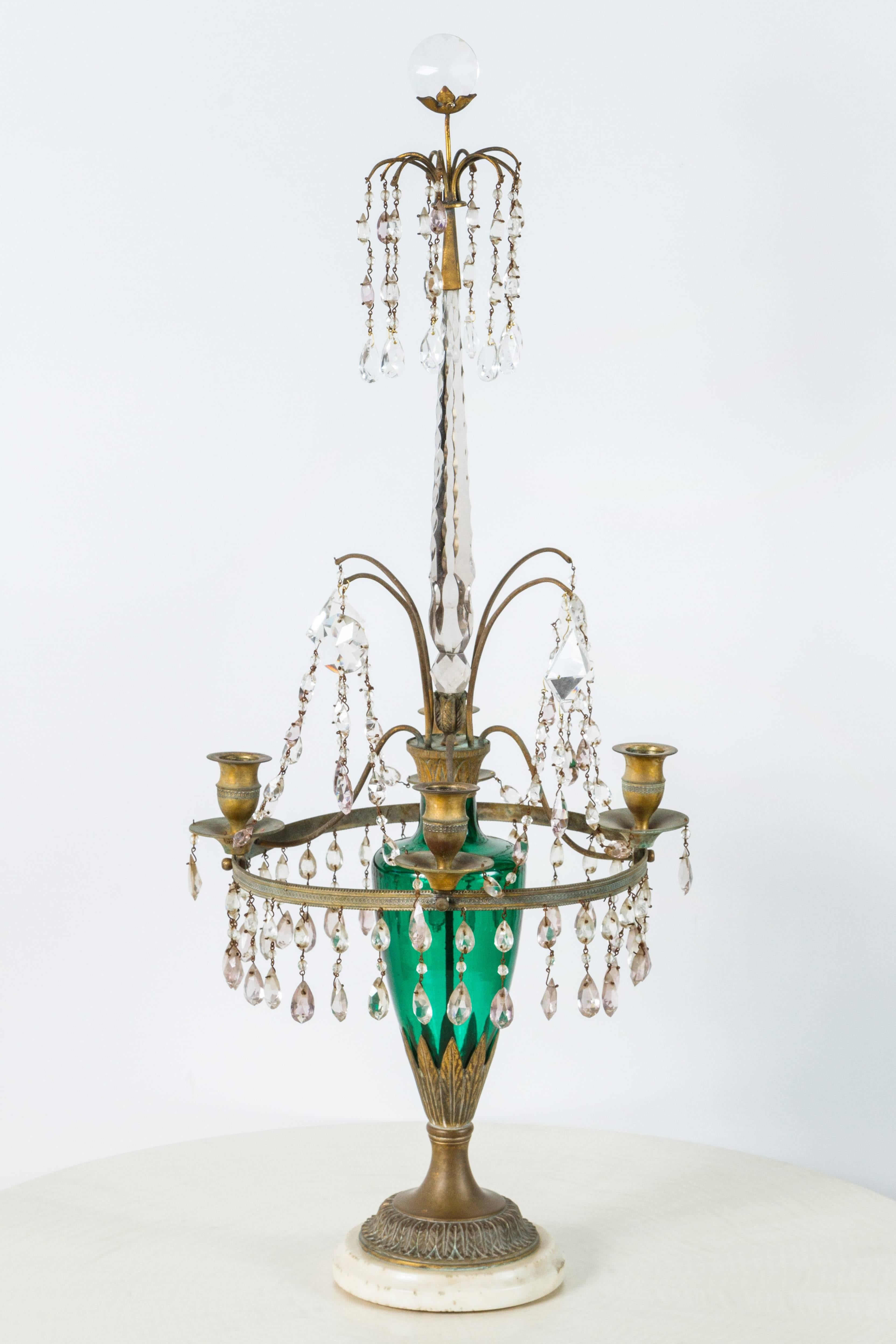 Pair of neoclassical gilt bronze girandole candelabra, late 19th century Gustavian Swedish style or Baltic Empire style. Emerald green baluster-form shaft. There has been much restoration including some of the crystal cut-glass. Marble base.