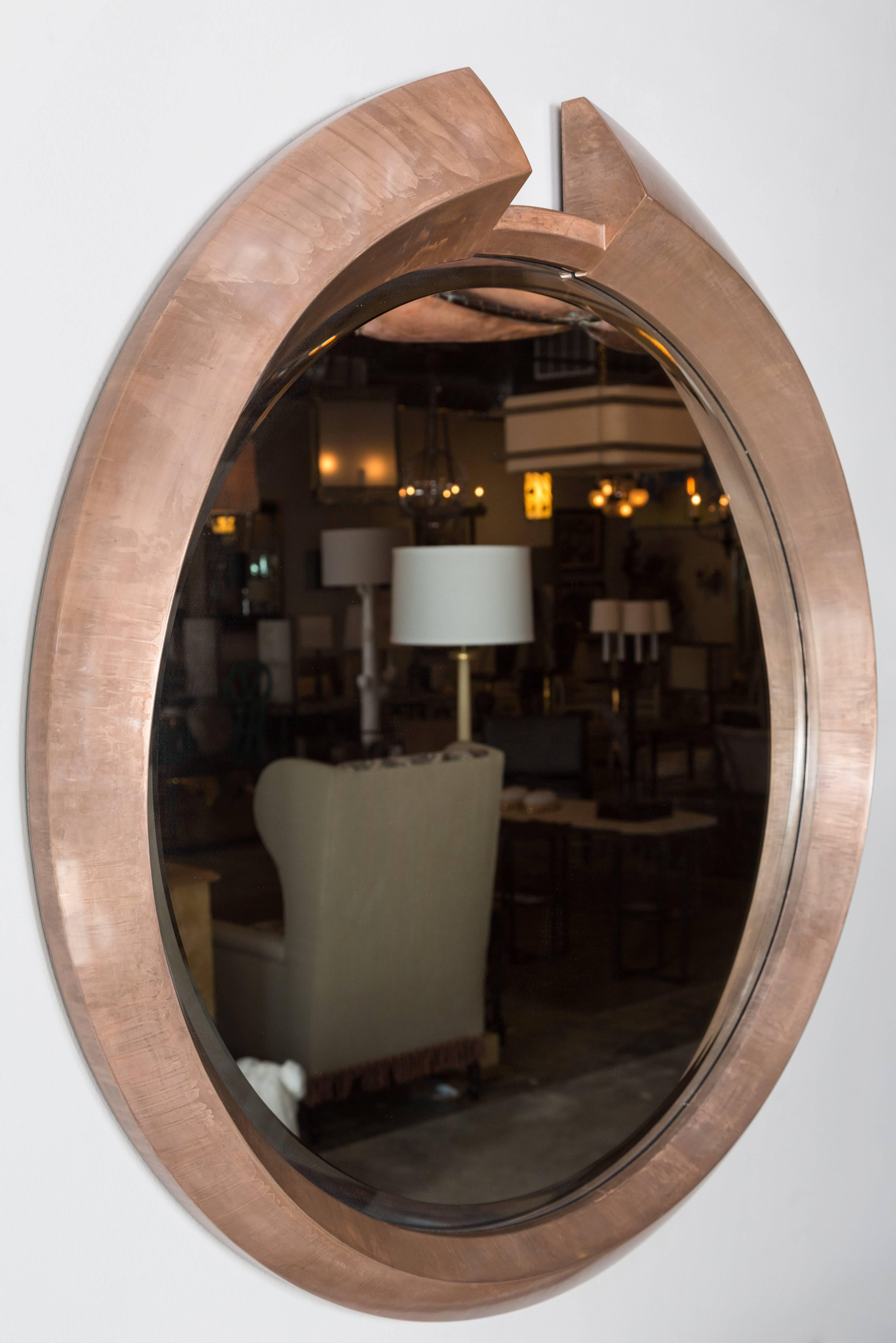 Large round modern architectural, split pediment mirror in a light bronze finish over wood. The finish results as if the frame is made of metal. By order.