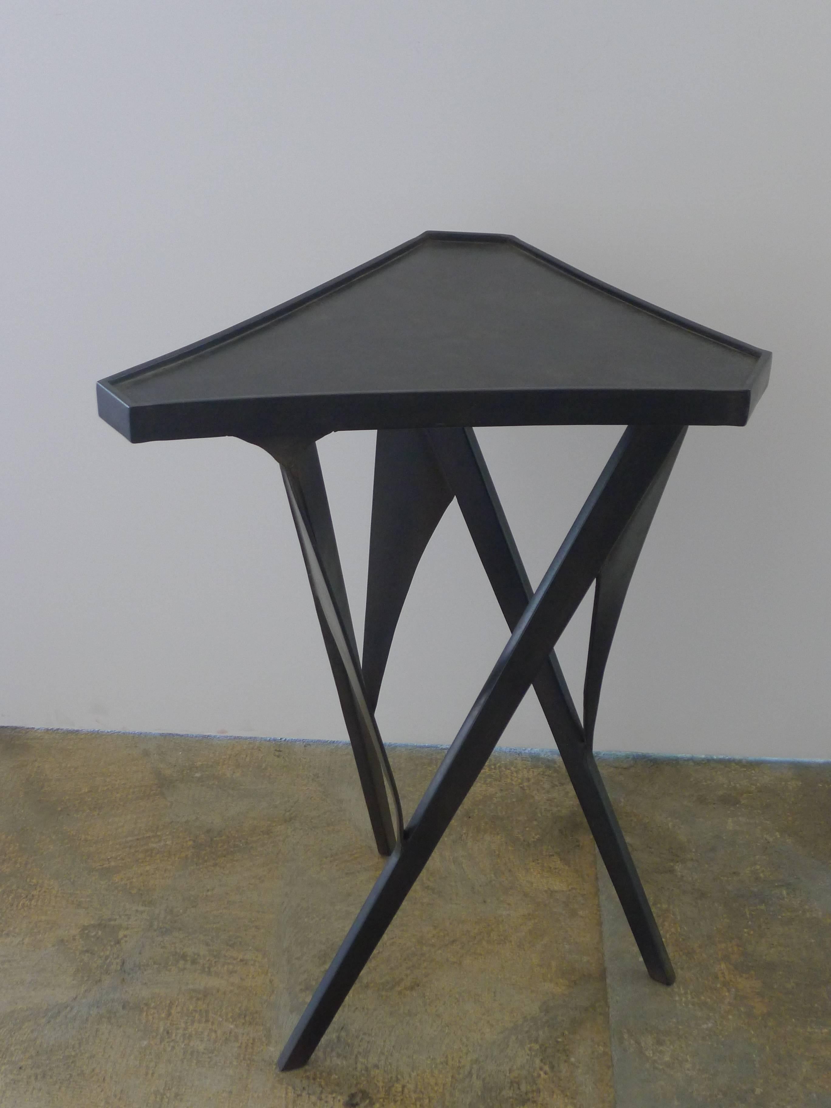 Paul Marra triangular steel side table. Modern table with sculptural base and bronze finish. Sides are slightly curved inward with raised edge detail. One in stock. Inquire for production lead time.