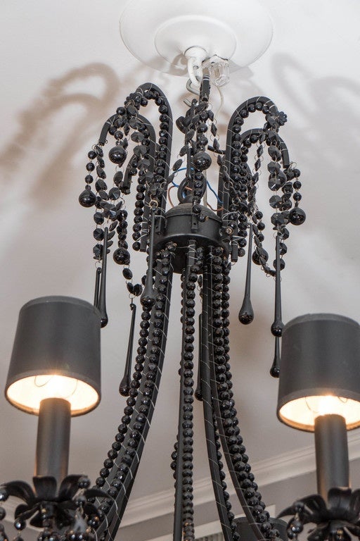 French black crystal chandelier, with beaded and teardrop crystal pendants and small black lamp shades.