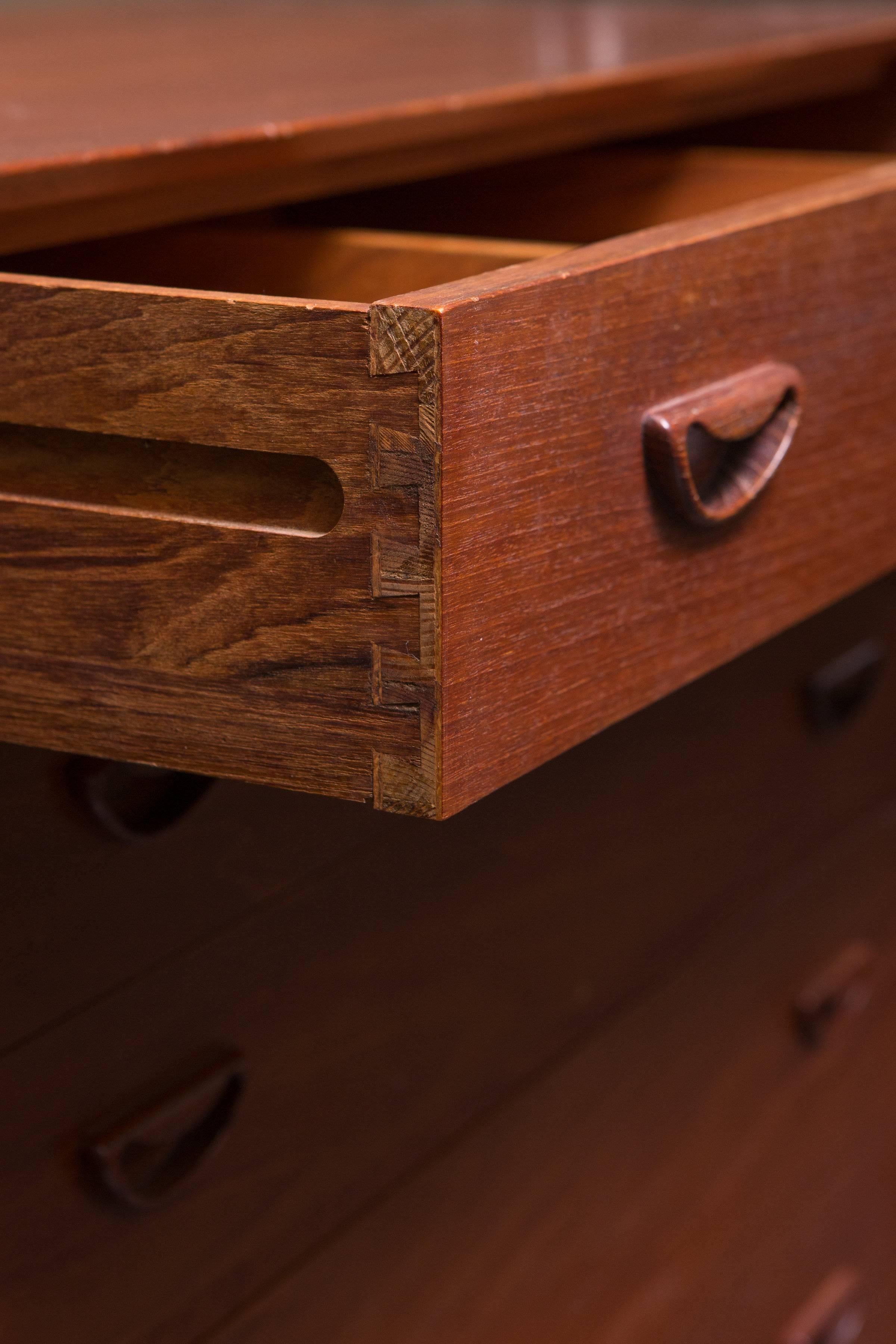 A modular five-drawer cabinet made of solid Burmese teak with beveled edged and finger joint detail. Designed by Peter Hvidt & Orla Mølgaard Nielsen.