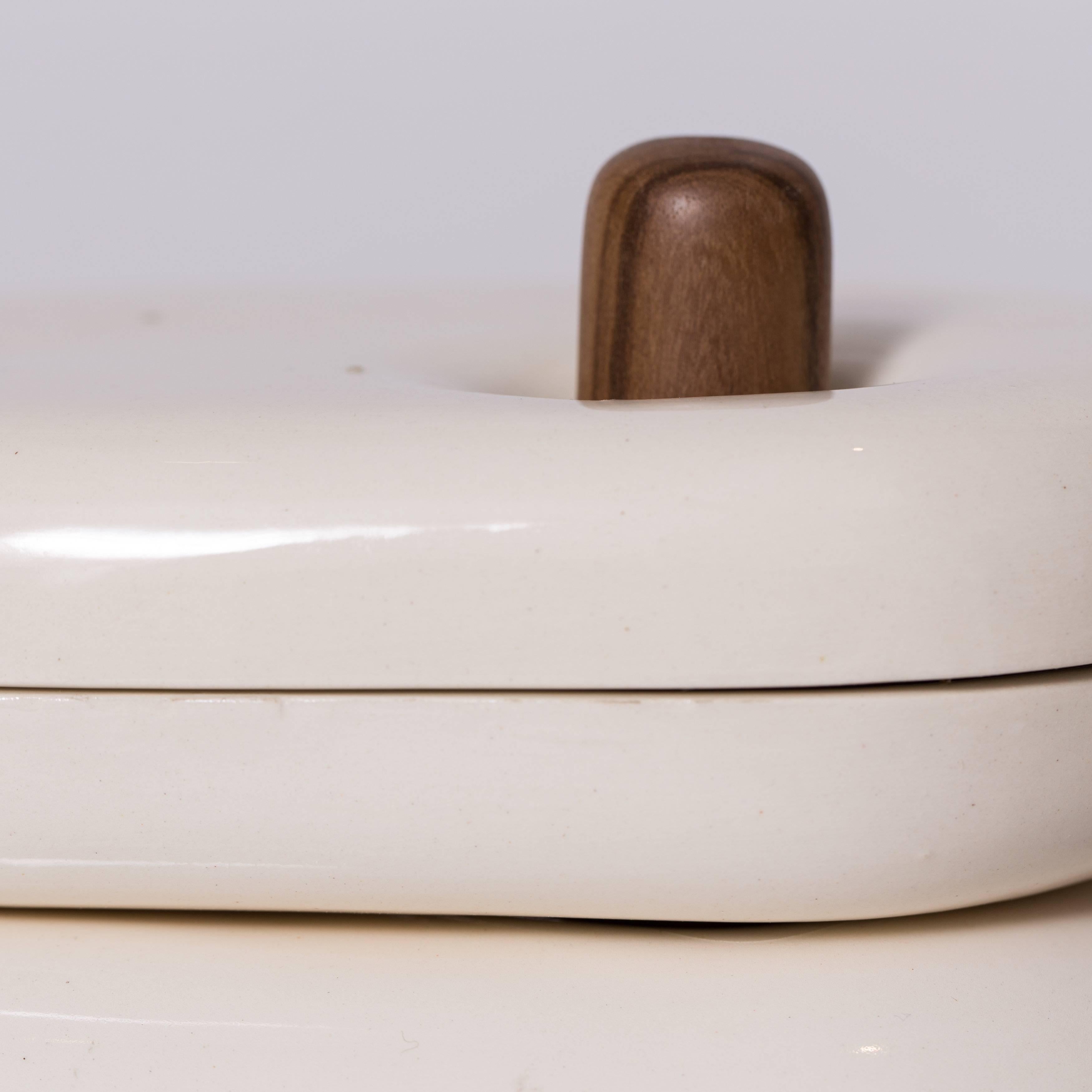 Gloss ceramic dish set on hand turned wood stand by El Salvadorian industrial designer, Maria Jose Nuñez. Maria's focus is on the mixture of crafts and new technology. Designed in 2014, this product was selected to represent El Salvador in the