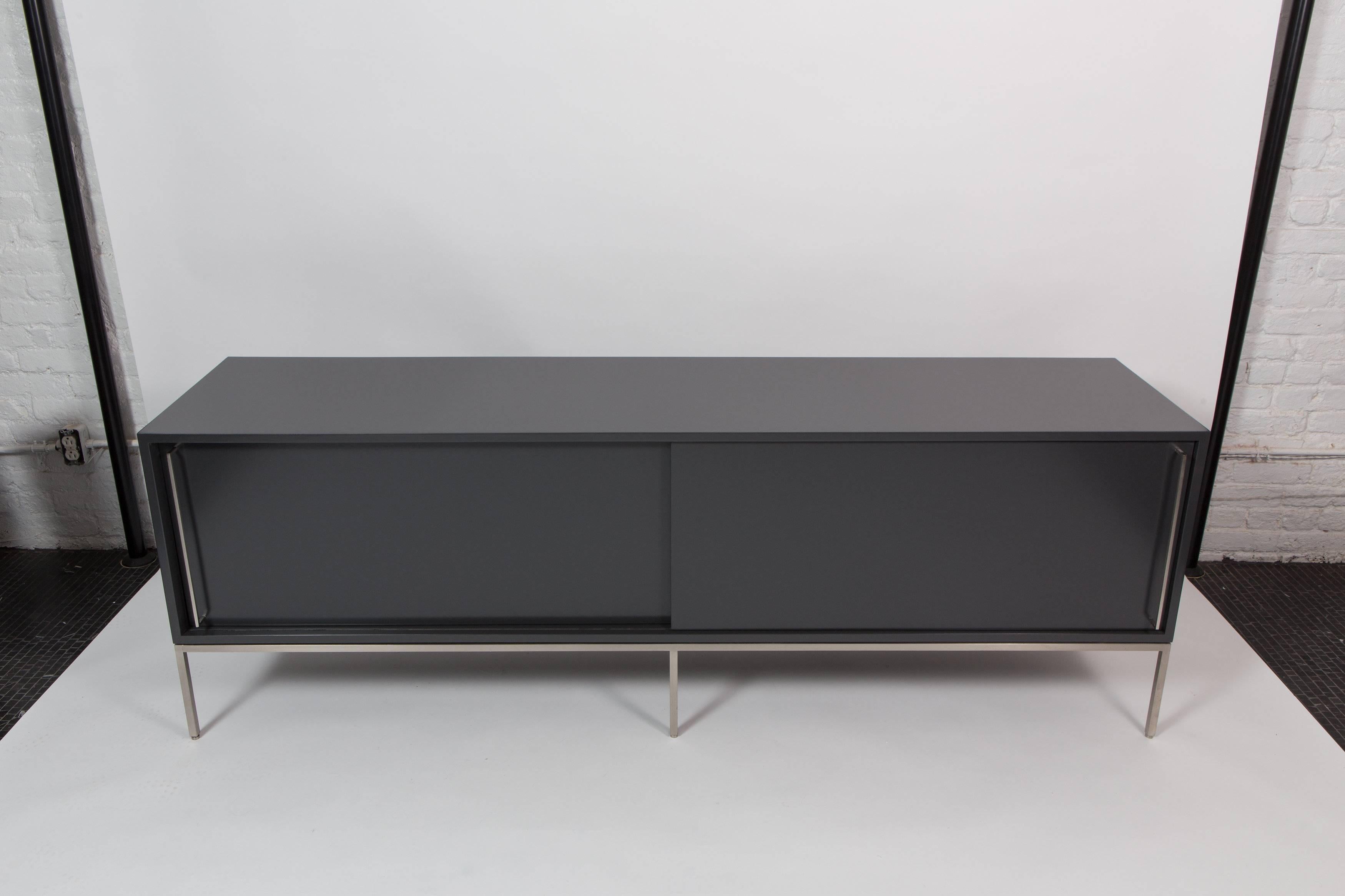 Floor model re: 379 credenza available and in stock in BM wrought iron satin lacquer on stainless steel base.  One adjustable shelf in each compartment.  This credenza has been a staple in our collection since 2011.