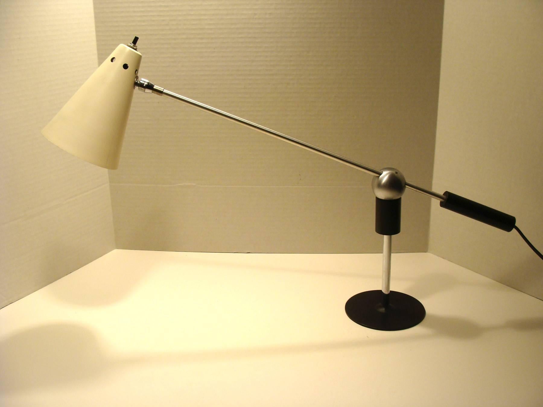 Iconic Mid-Century table/desk lamp designed by Gilbert Watrous
for Heifetz. Enameled white aluminum conical shade and brushed steel
magnetic ball and armature.
Measures: Arm length is 23