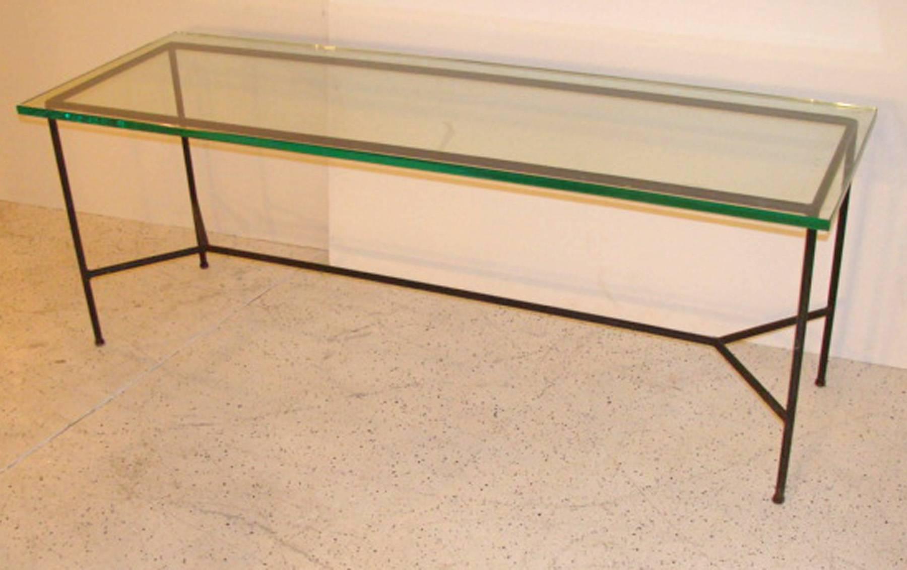 In the manner of Paul McCobb, this minimal table probably supported a wood top in its original state.  Now with a thick glass top.   Frame is blackened steel rod with old possibly original finish.