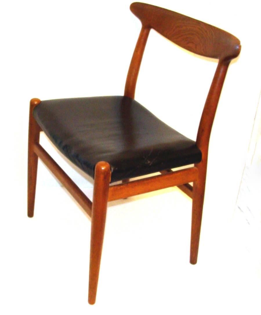 Excellent set of four Wegner chairs for C.M. Madsens, Denmark. Classic early 1950s design in beautiful old/original finish. Crafted of oak with nice swirly grain and smoky patina. Frames structurally sound.
Three chairs retain original black