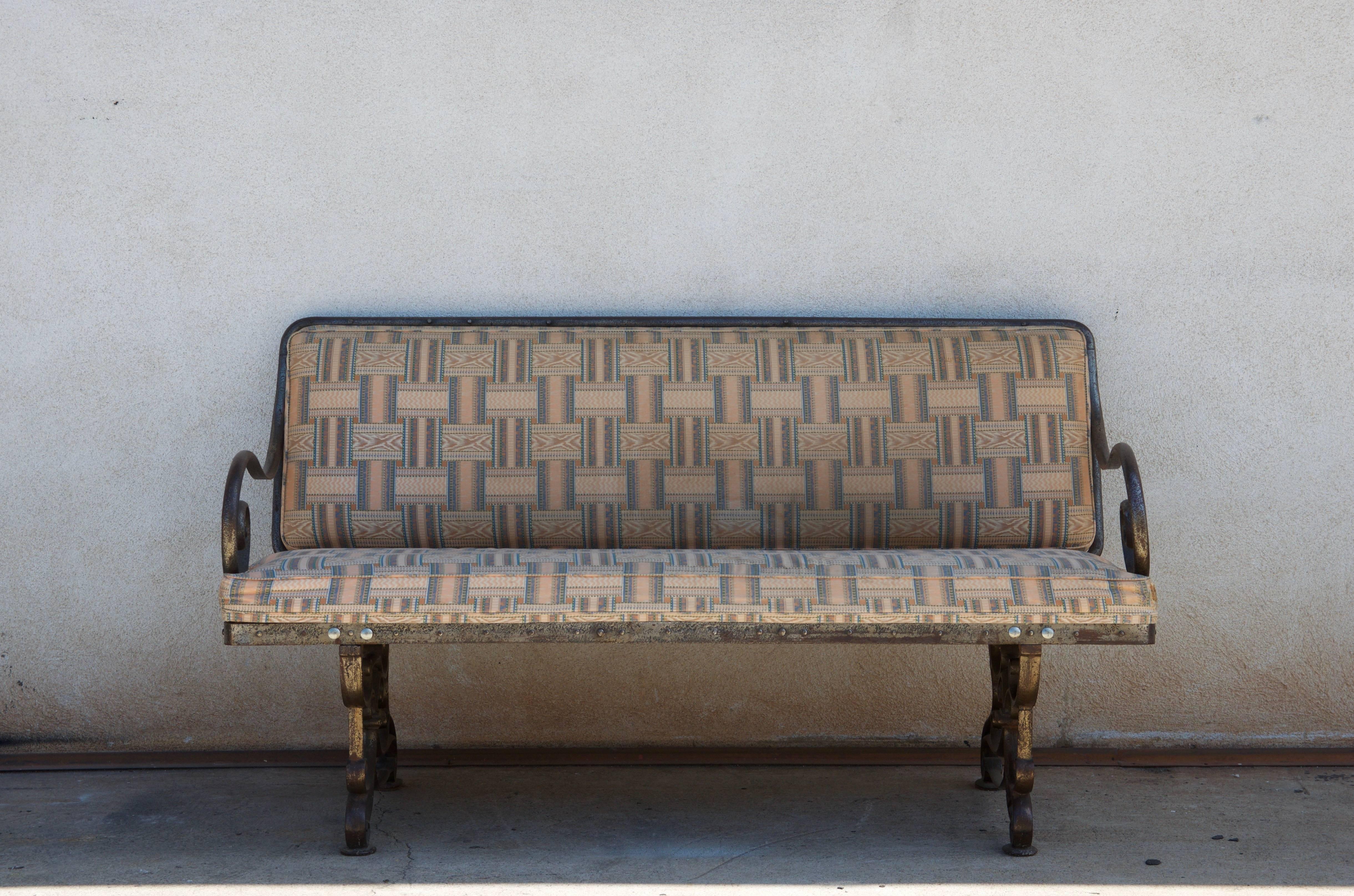 Pair of comfortable French Art Nouveau industrial benches. Also sold individually. Heavy and sturdy wrought iron base. Great for dining. Would need to be reupholstered with C. O. M.