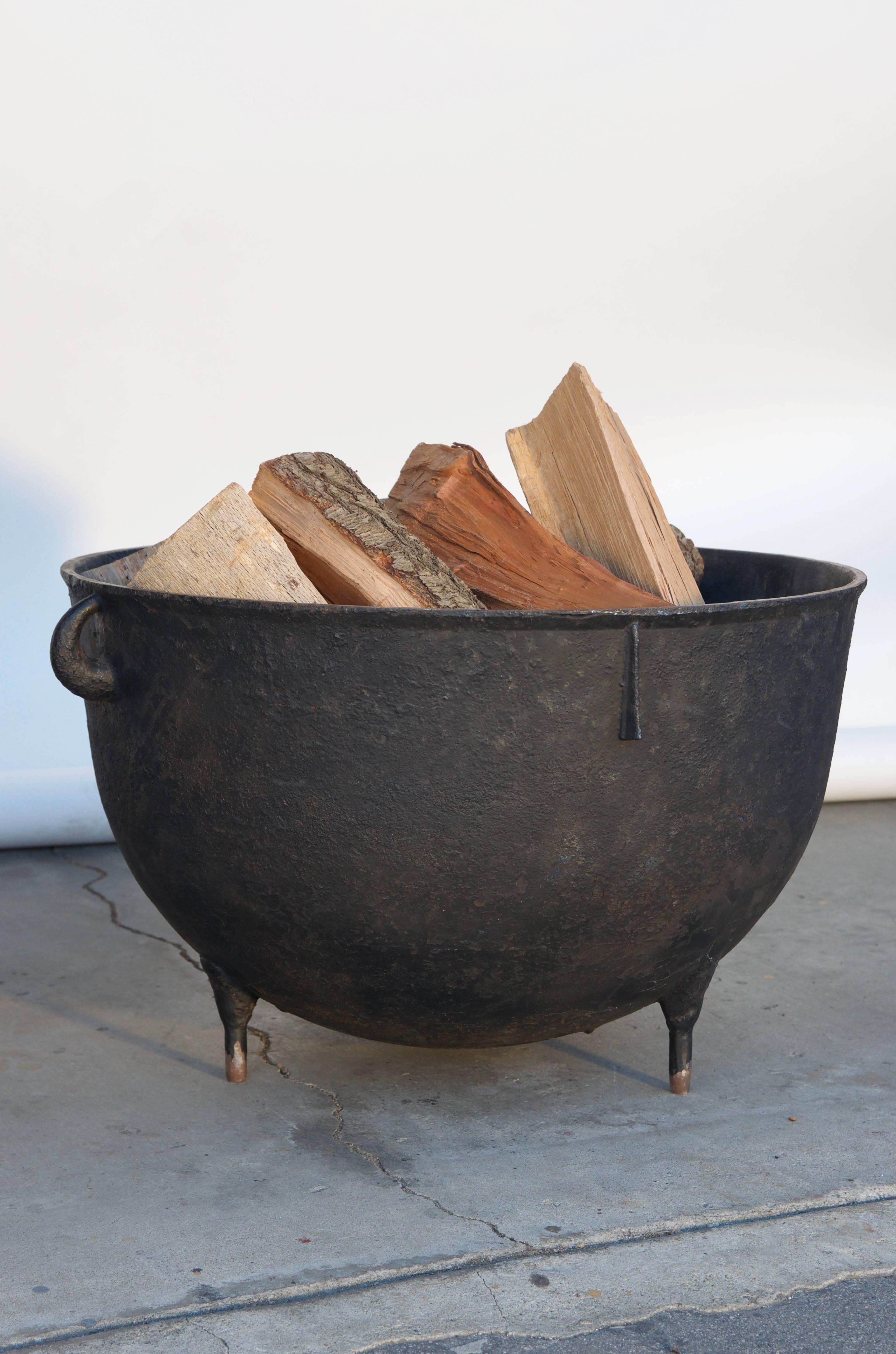 Large patinated iron cauldron wood holder. Great next to a fireplace.