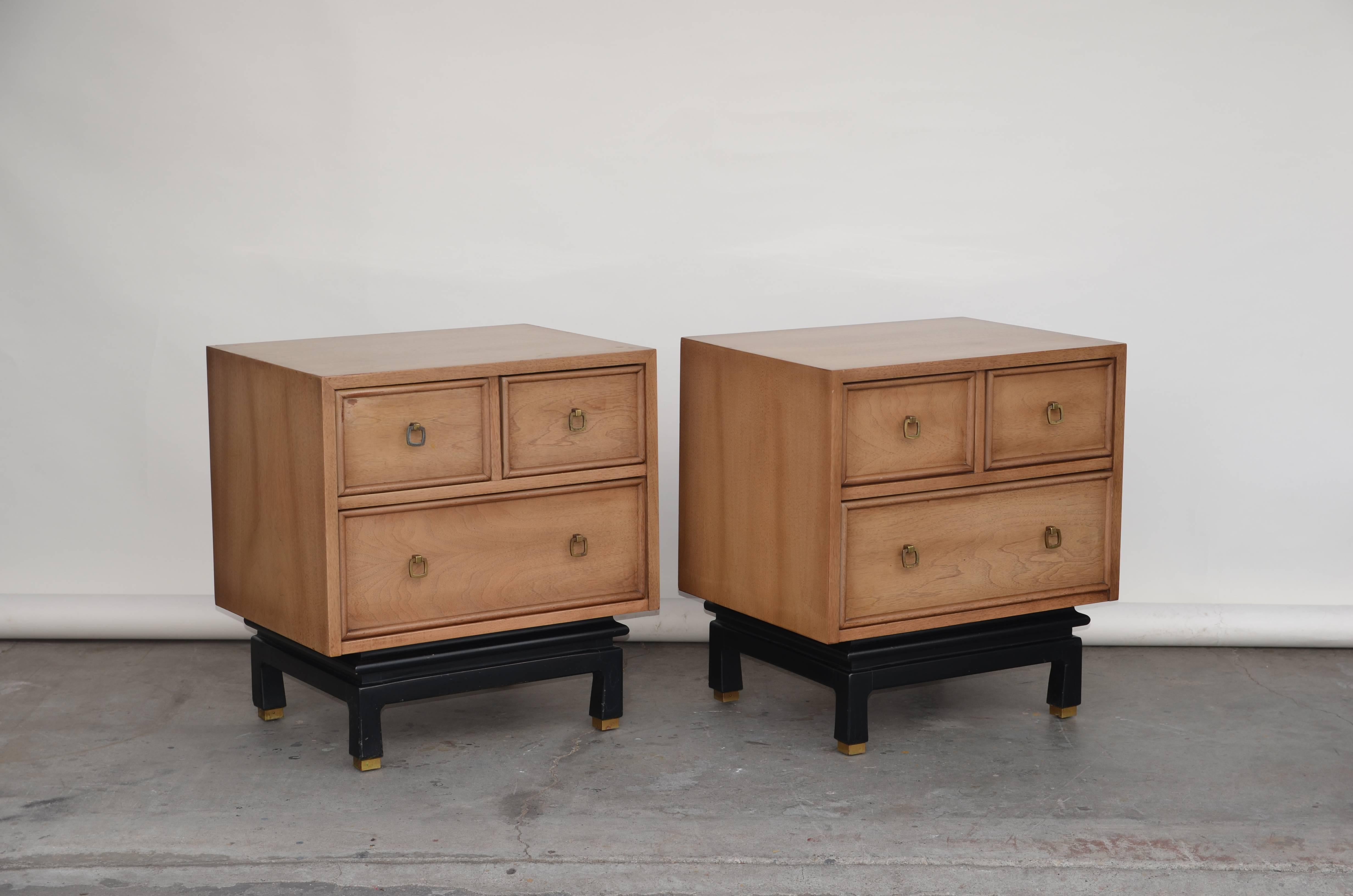 Pair of bleached oak nightstands by American of Martinsville. Ebonized base and patinated brass hardware and accents. Stamped.