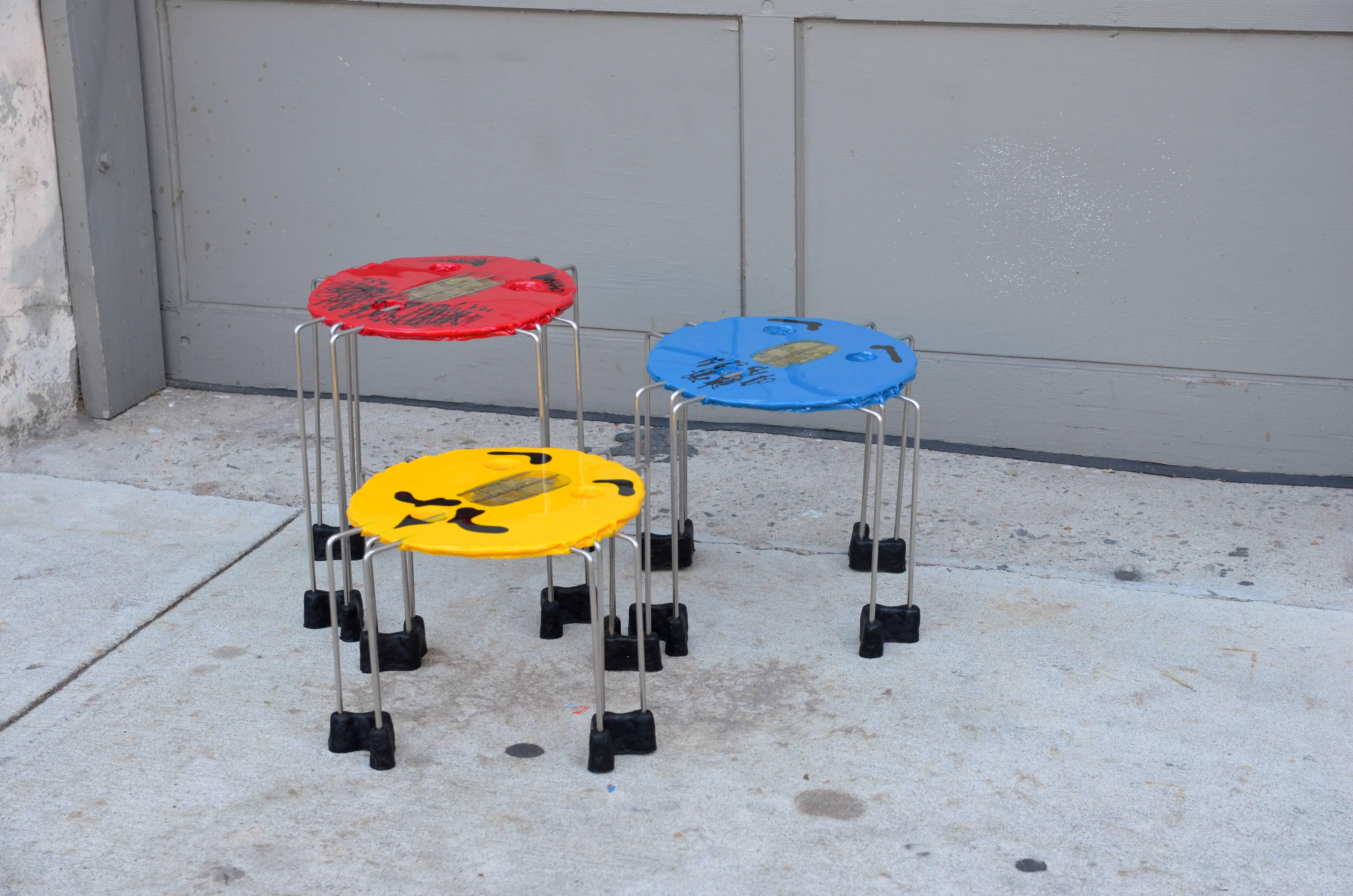 Set of whimsical colored side tables by Gaetano Pesce. 15 in. diameter each. 14 in. height is for the tallest red table. 12 in. tall blue one. 9 in. tall yellow one.