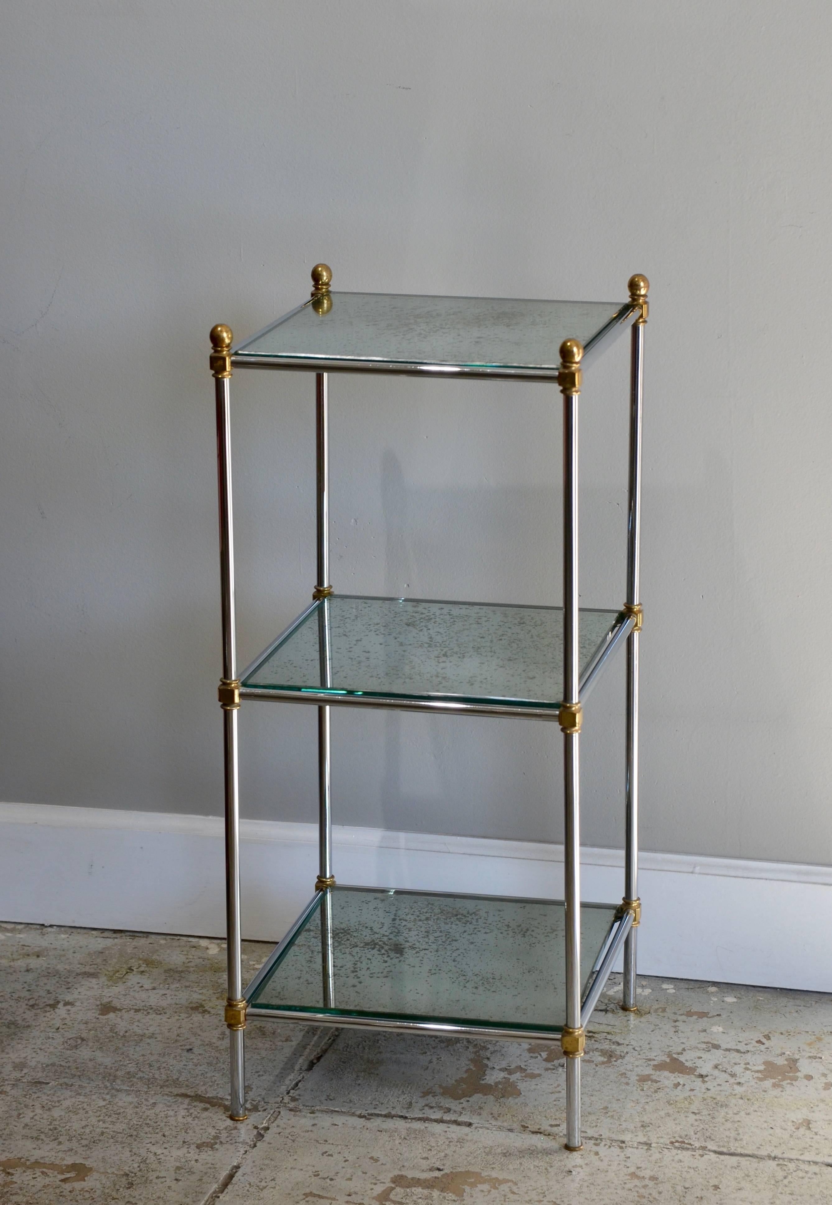 Pair of chic French 1960s three-tiered mirrored side tables. Provenance: Hotel Royal Monceau. New antiqued mirror tops.