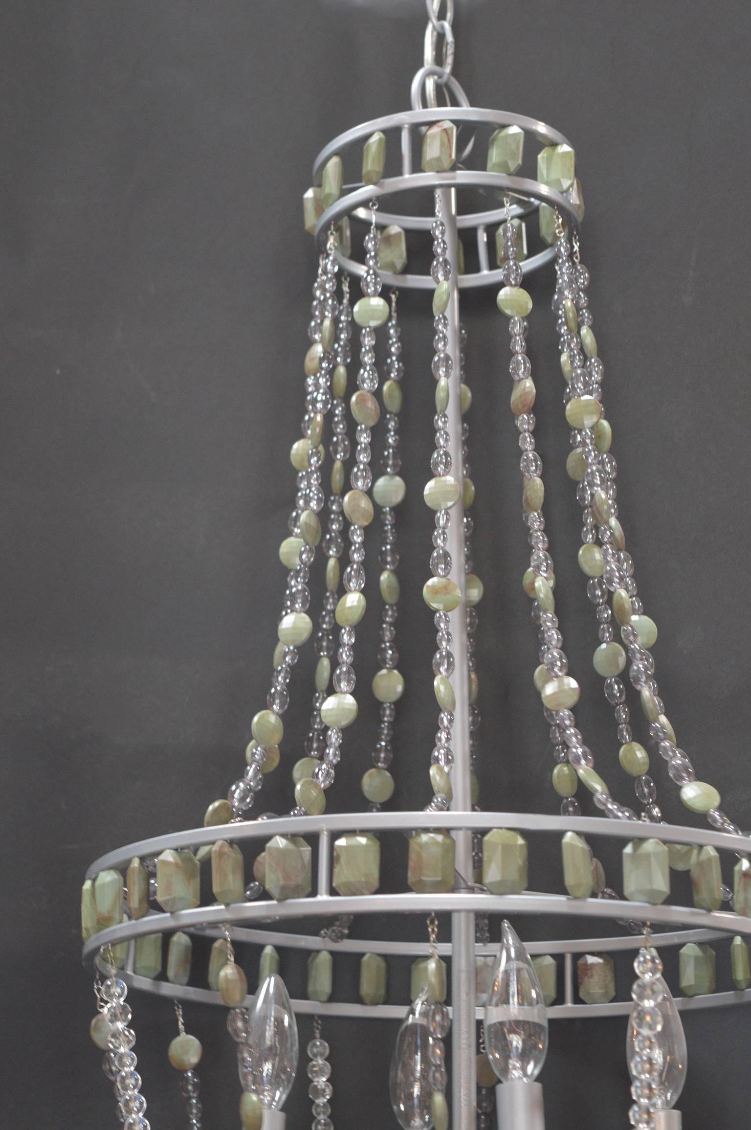 Hollywood Regency chandelier with green gemstones.
