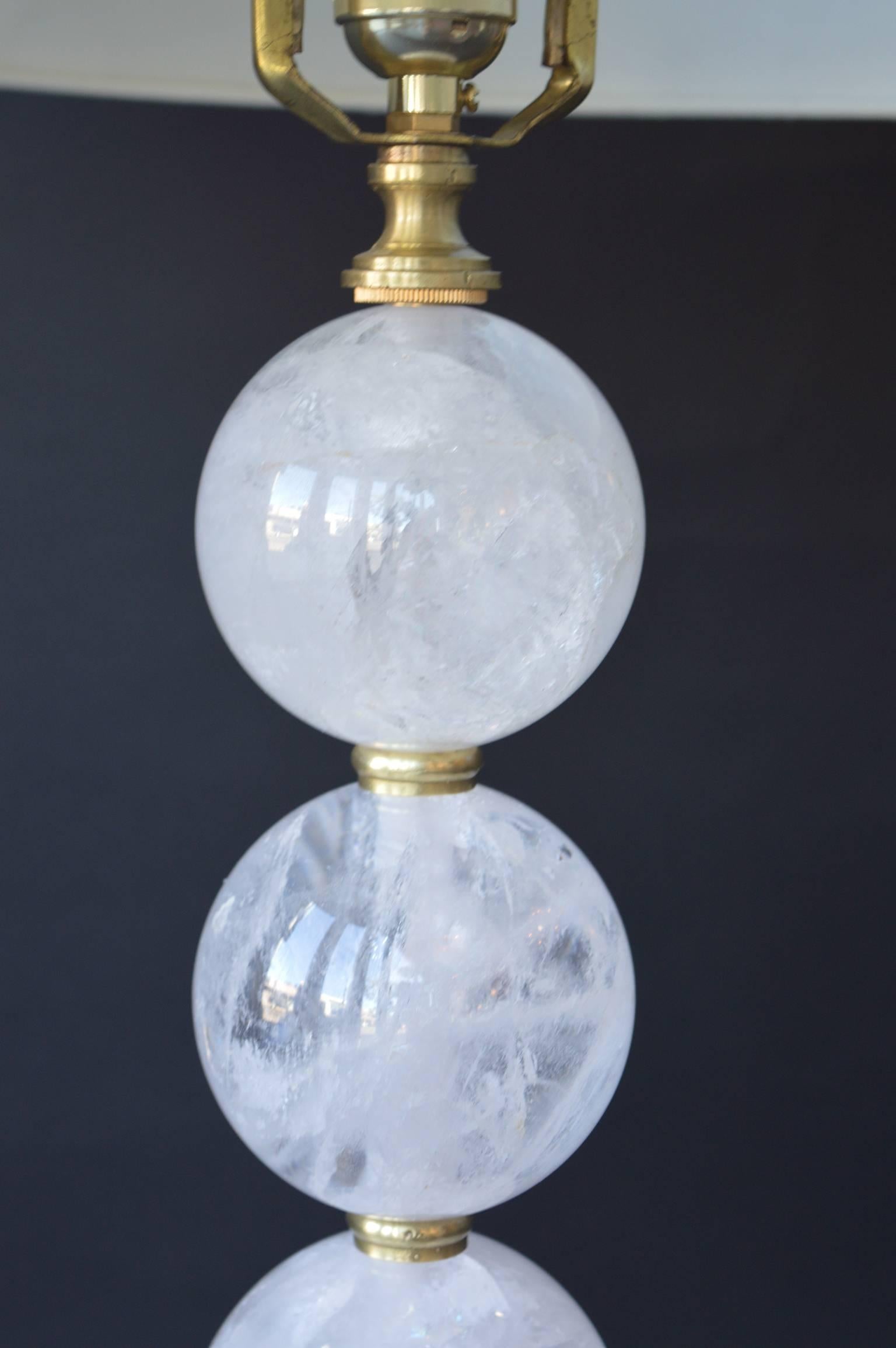 Five rock crystal spheres make up the stem of the table lamp with a Lucite pyramid base and brass feet. Rock crystal is antique from Brazil, but carved in the US. The lamp shade can be interchangeable.
 