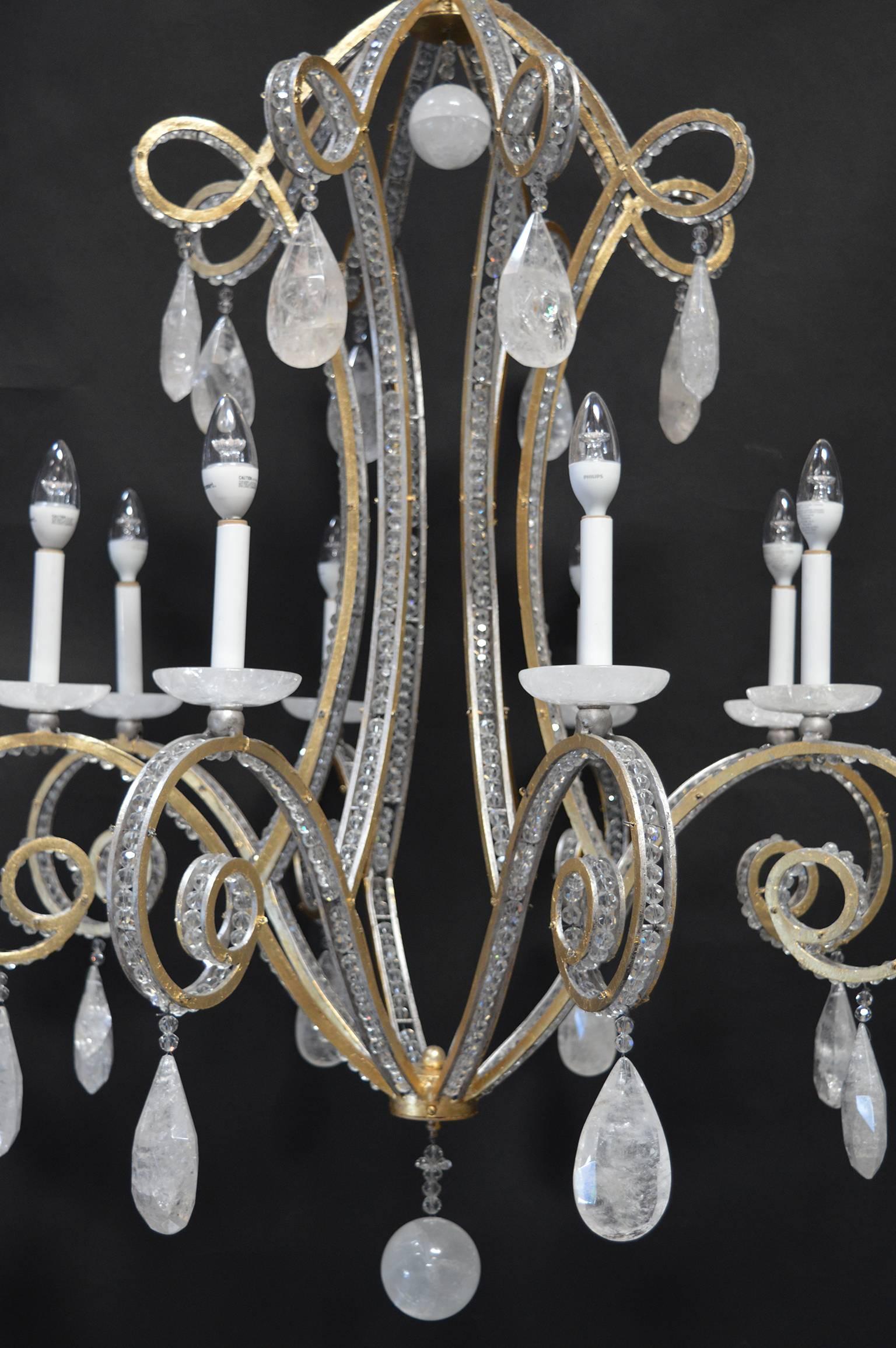 Rock crystal and gold leafed iron. Silver leafing on the outer edges along side the crystal beading embedded in the arms. 
The chandelier was designed and made in Italy, but the rock crystal was mined in Brazil.