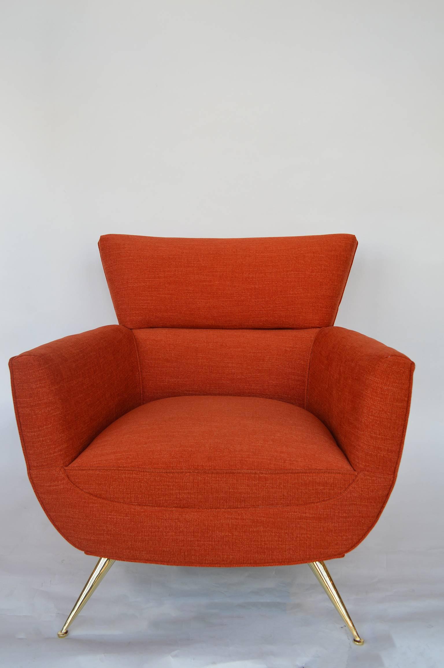 Pair of Tommi Parzinger armchairs. Polished brass feet. Newly upholstered in a vibrant orange fabric.