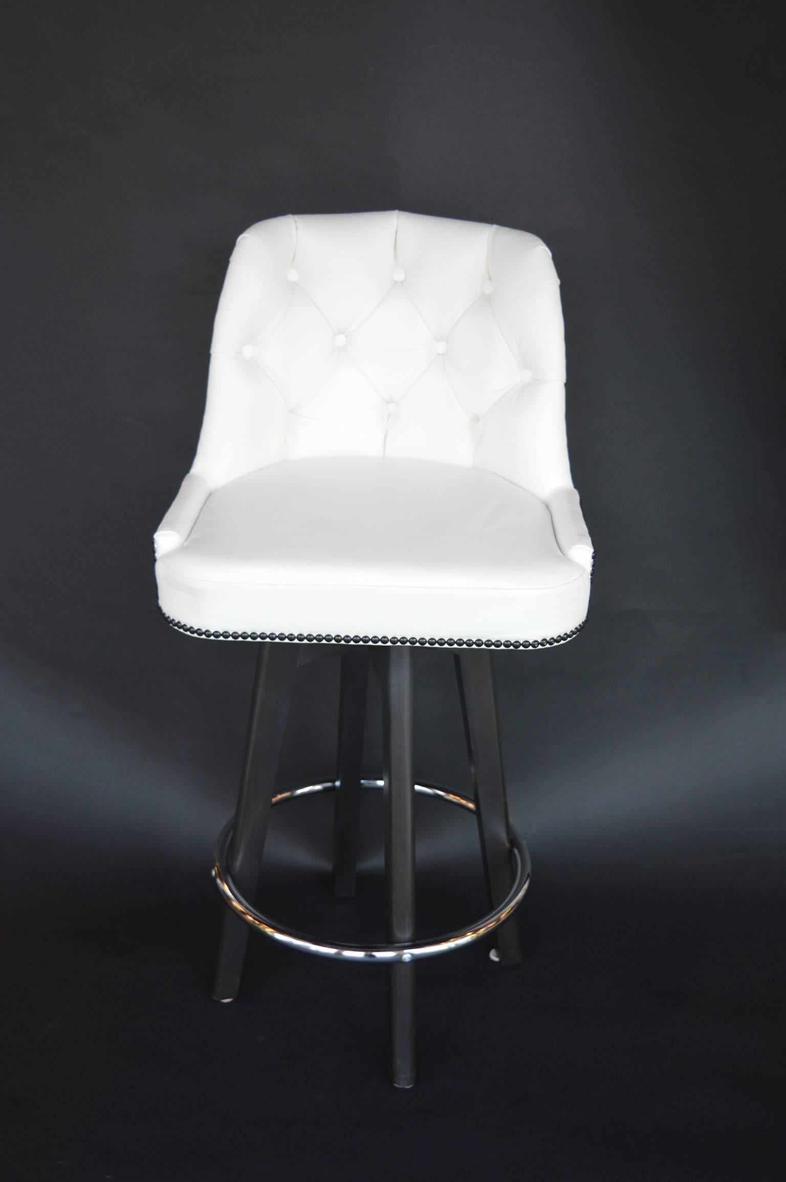 Set of three white leather bar stools. Tufted backs with black nailhead accent.