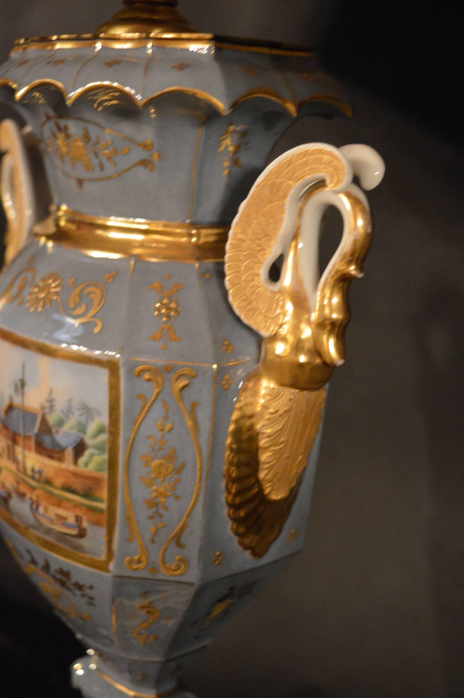 Pair of Italian porcelain lamps, with details of an Asian market hand-painted on the front, back and base.