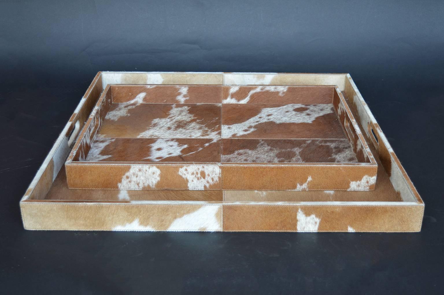 Set of two cowhide trays. Smaller tray measures 18