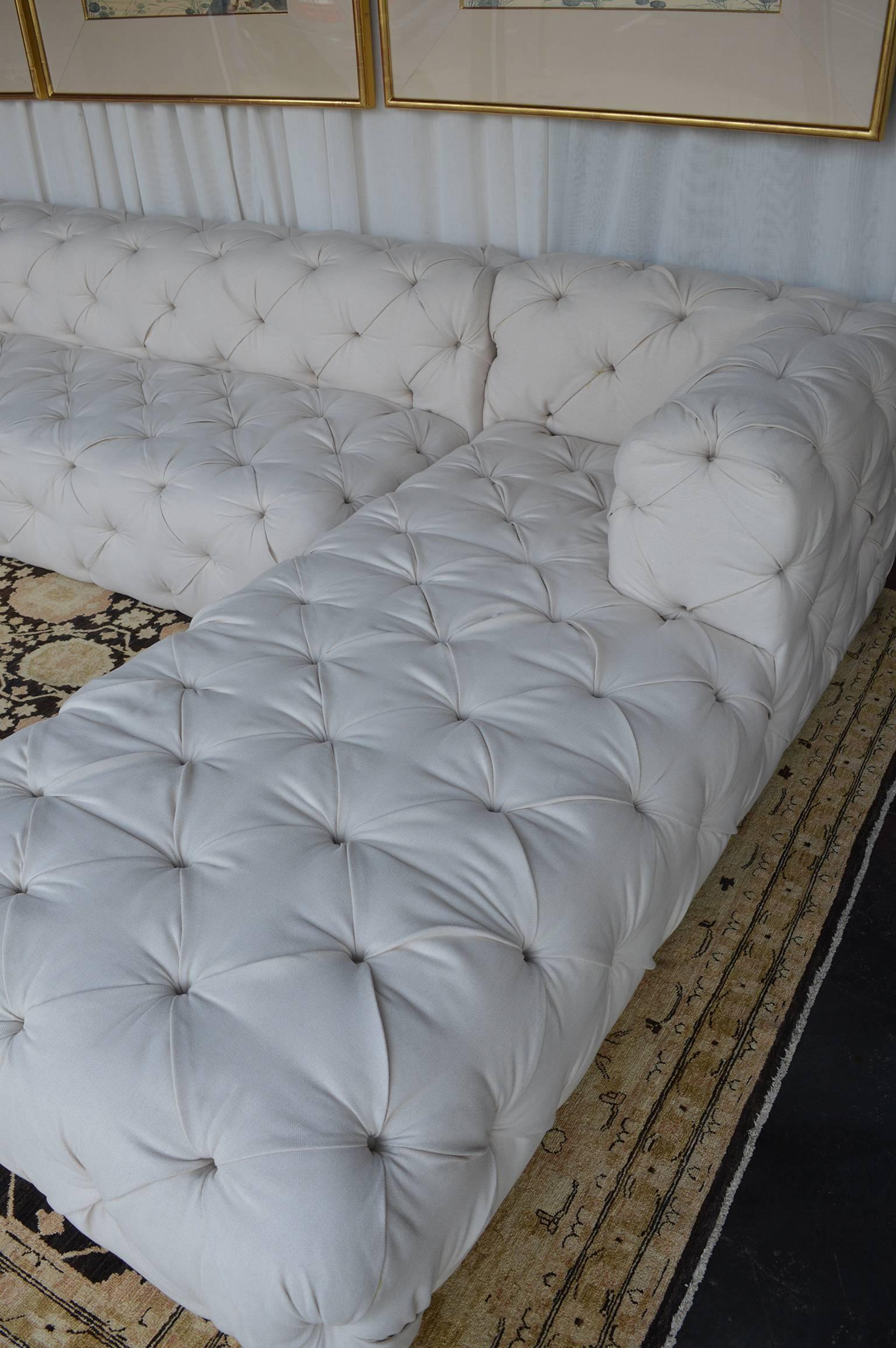 Large tufted sofa, with two lounges framing the outside of the couch.