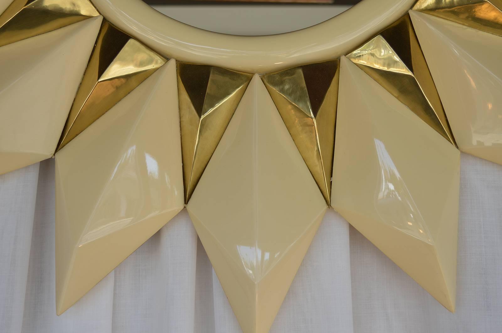 Pair of sunburst mirrors. Wood frames painted in a cream lacquer with brass accents.