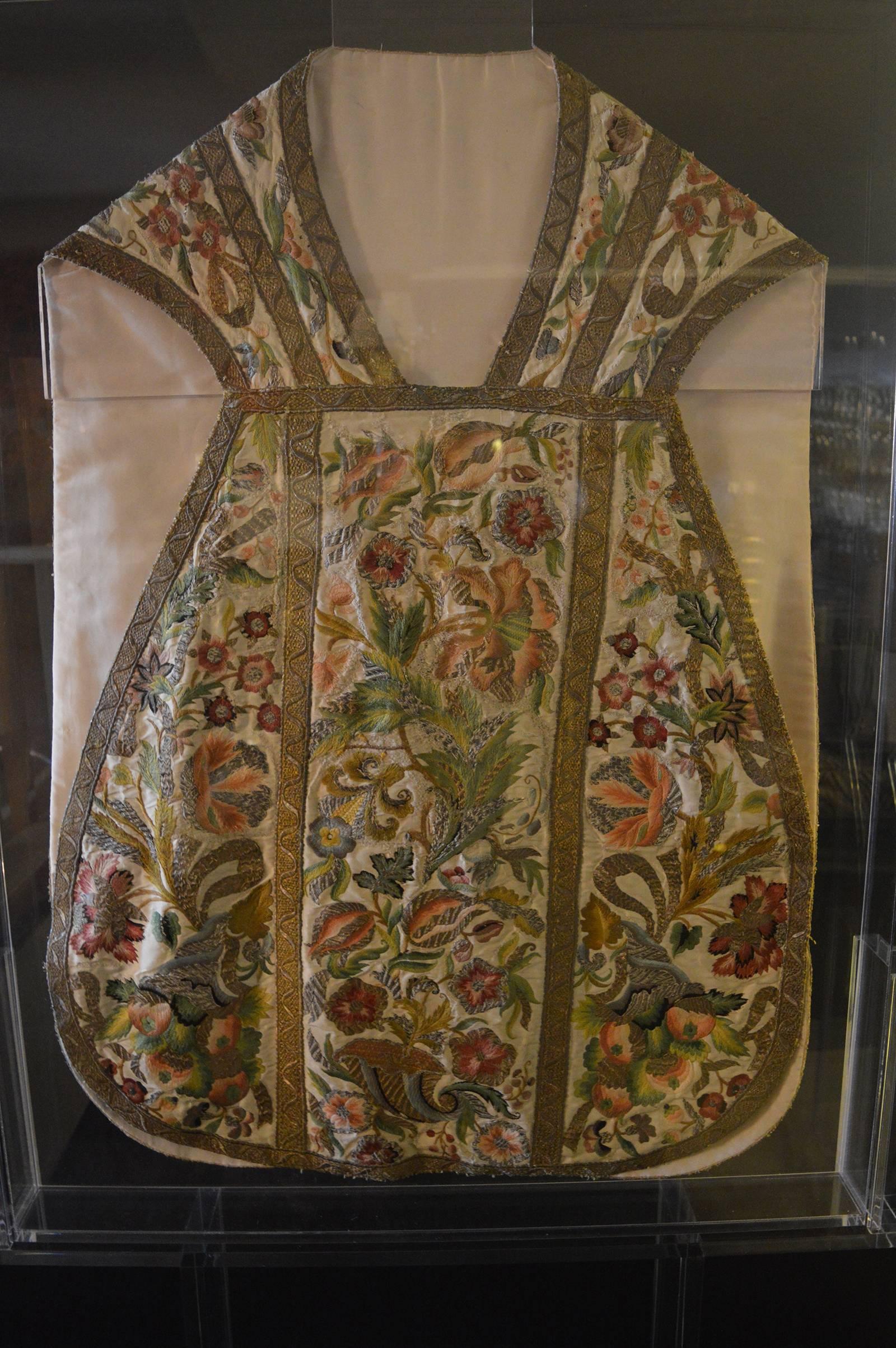 Embroidered floral Chasuble. Custom Acrylic frame and stand. Hand embroidery. Gold accents are sewn with brass thread.