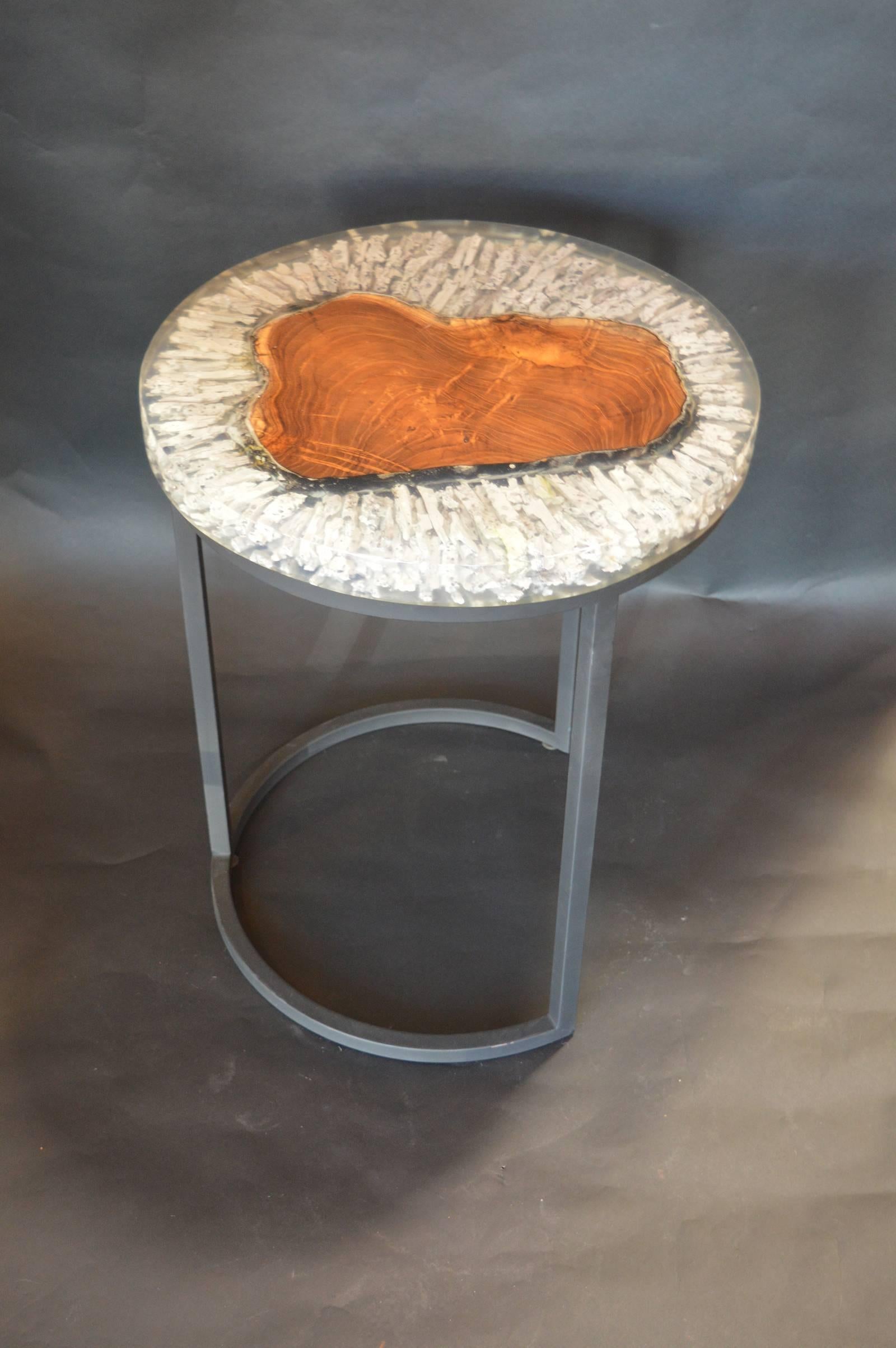 Wood and resin side table with metal base.