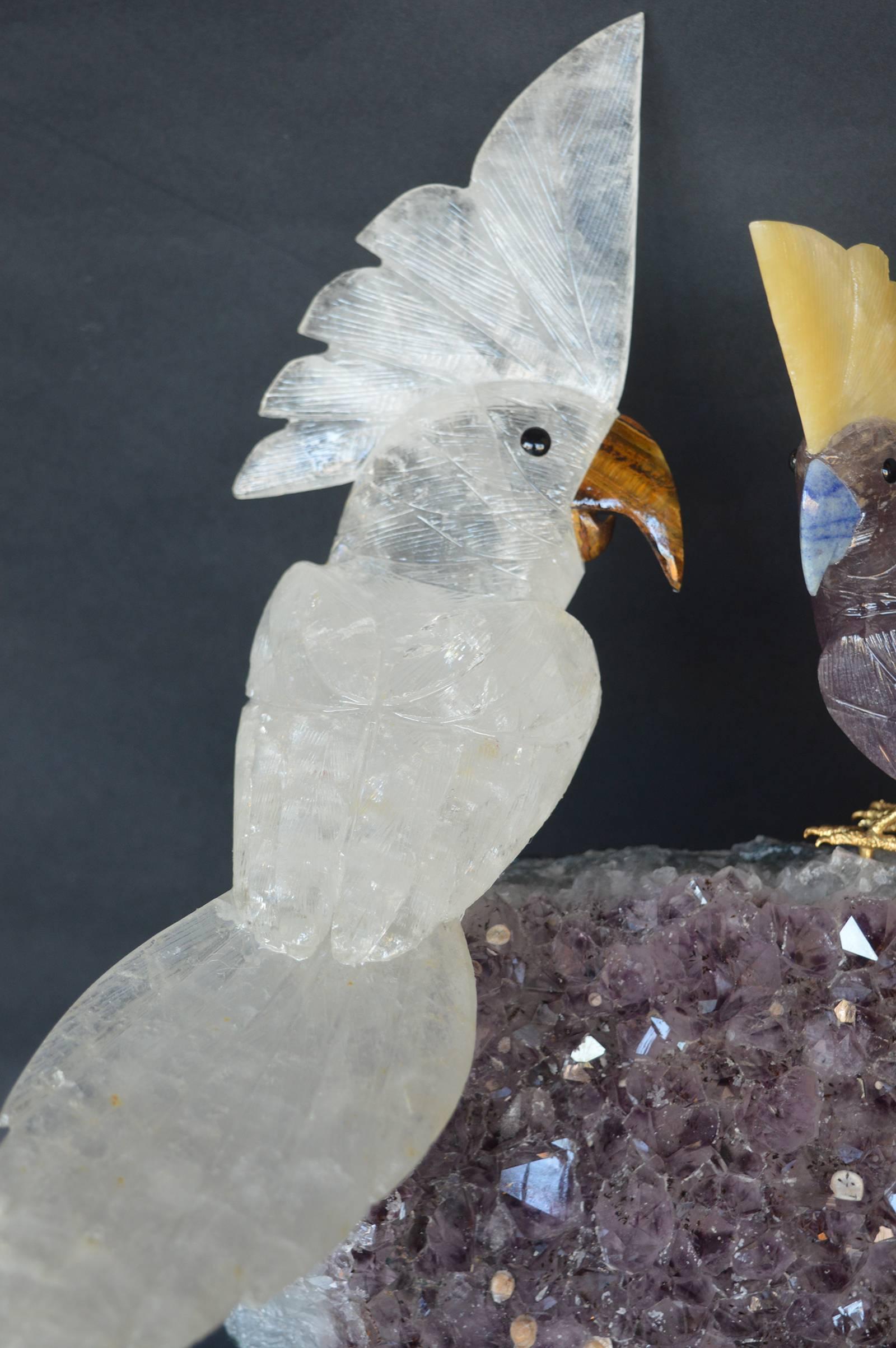 Rock crystal and quartz with tiger eye birds perched on a piece of quartz.