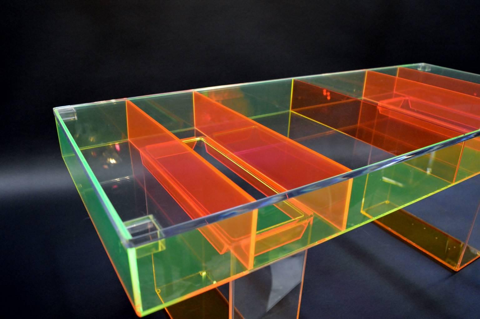 Custom multicolored Lucite coffee table. The tabletop base is lime green with bright orange legs and dividing pieces. The clear Lucite top of the table is removable, to place collectors items inside to present.