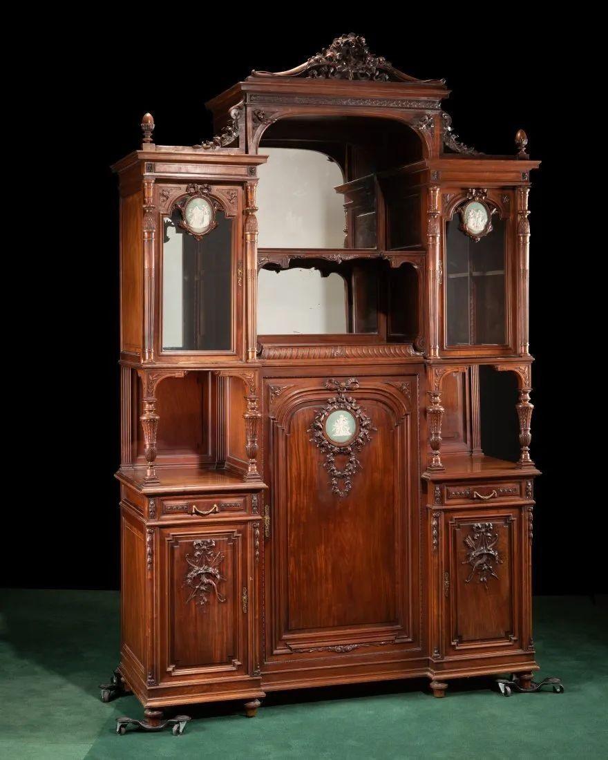 Un magnifico mobile francese della fine del XIX secolo, sapientemente realizzato in noce riccamente intagliato, caratterizzato da un elegante stemma con dettagli di nastri e ghirlande che esemplificano la grandezza delle arti decorative francesi.