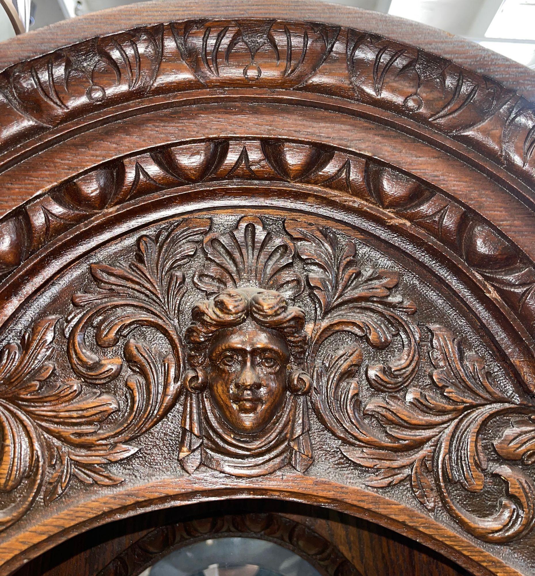 Beautiful and substantial American quarter-sawn oak sideboard dating to the 1880s. This richly detailed Victorian piece features a central beveled mirror flanked by two side mirrors, adding depth and elegance. A display shelf bridges the mirrors,