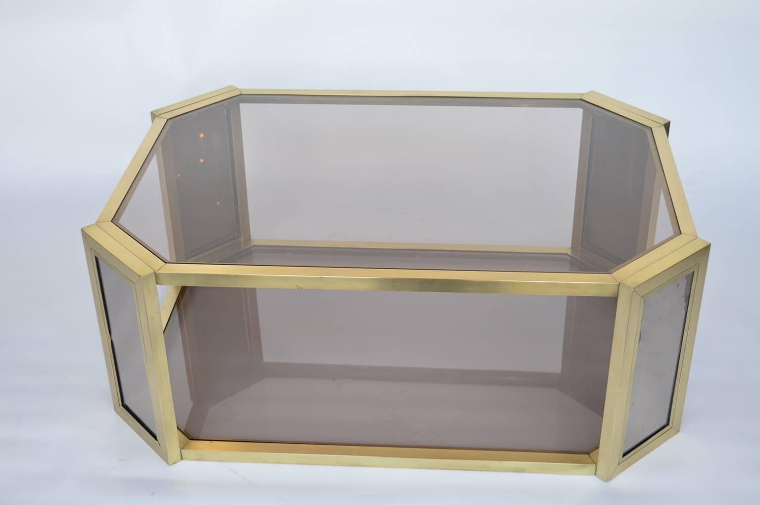 Brass mirrored coffee table. Table has two tiers of a light brown glass, with matching mirrors on the inside and outside of the legs.