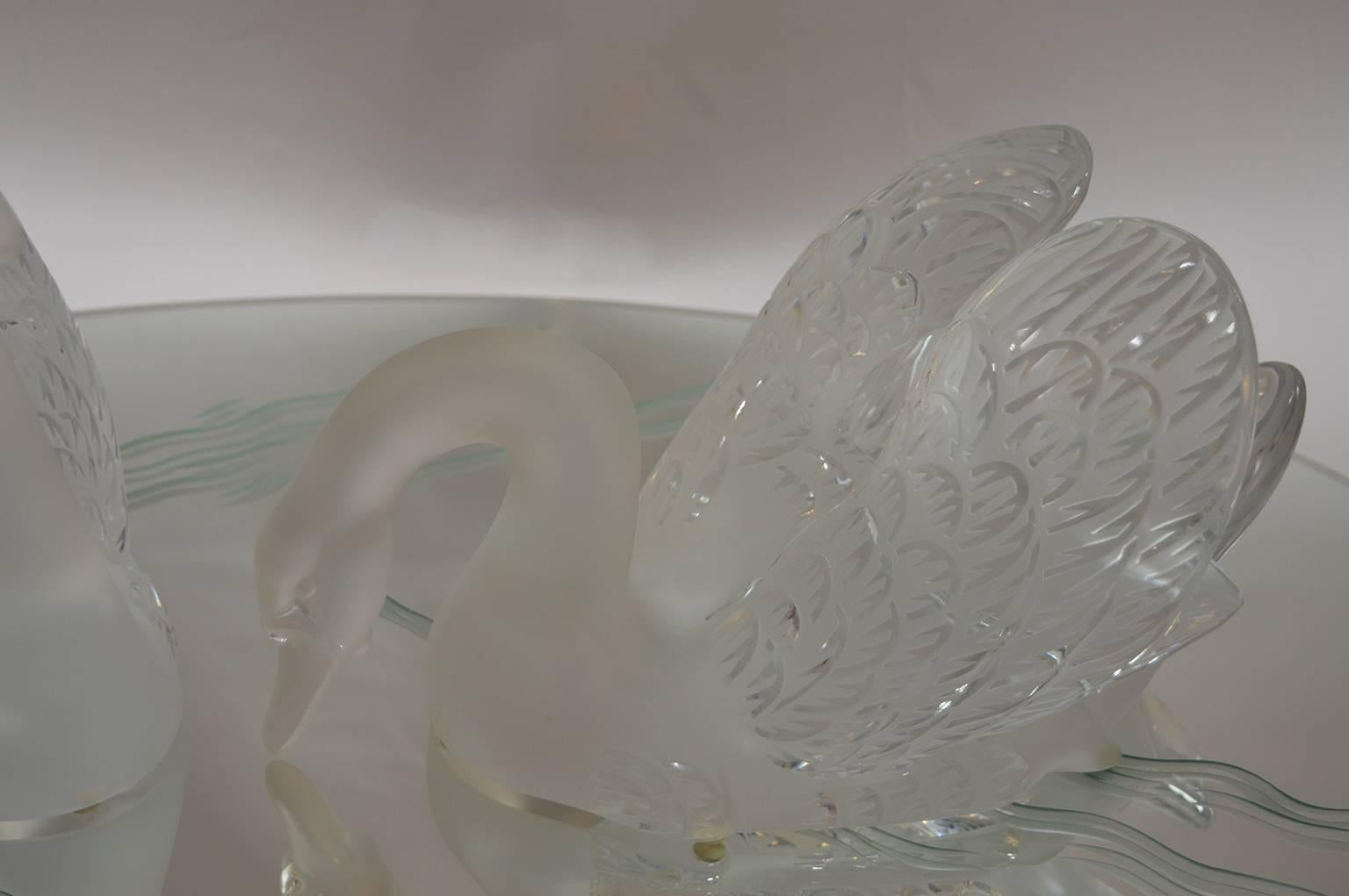 Pair of Lalique swans on an etched mirror plateau.
