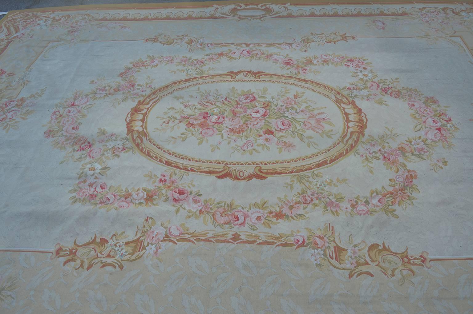Handwoven Aubusson rug with pink flowers and golden accents.