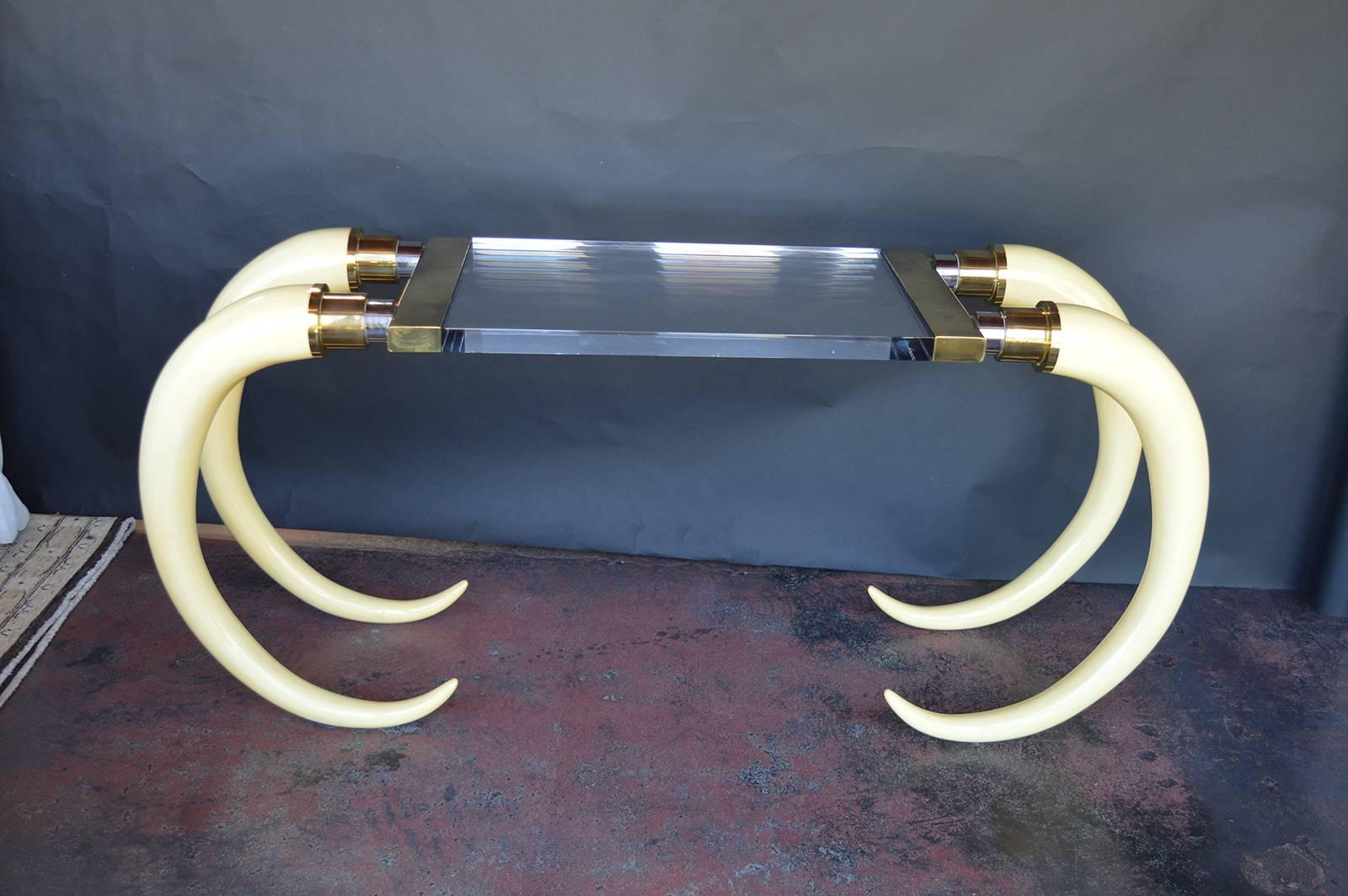 Lucite and faux tusk console with brass hardware. The Tusks are painted wood.