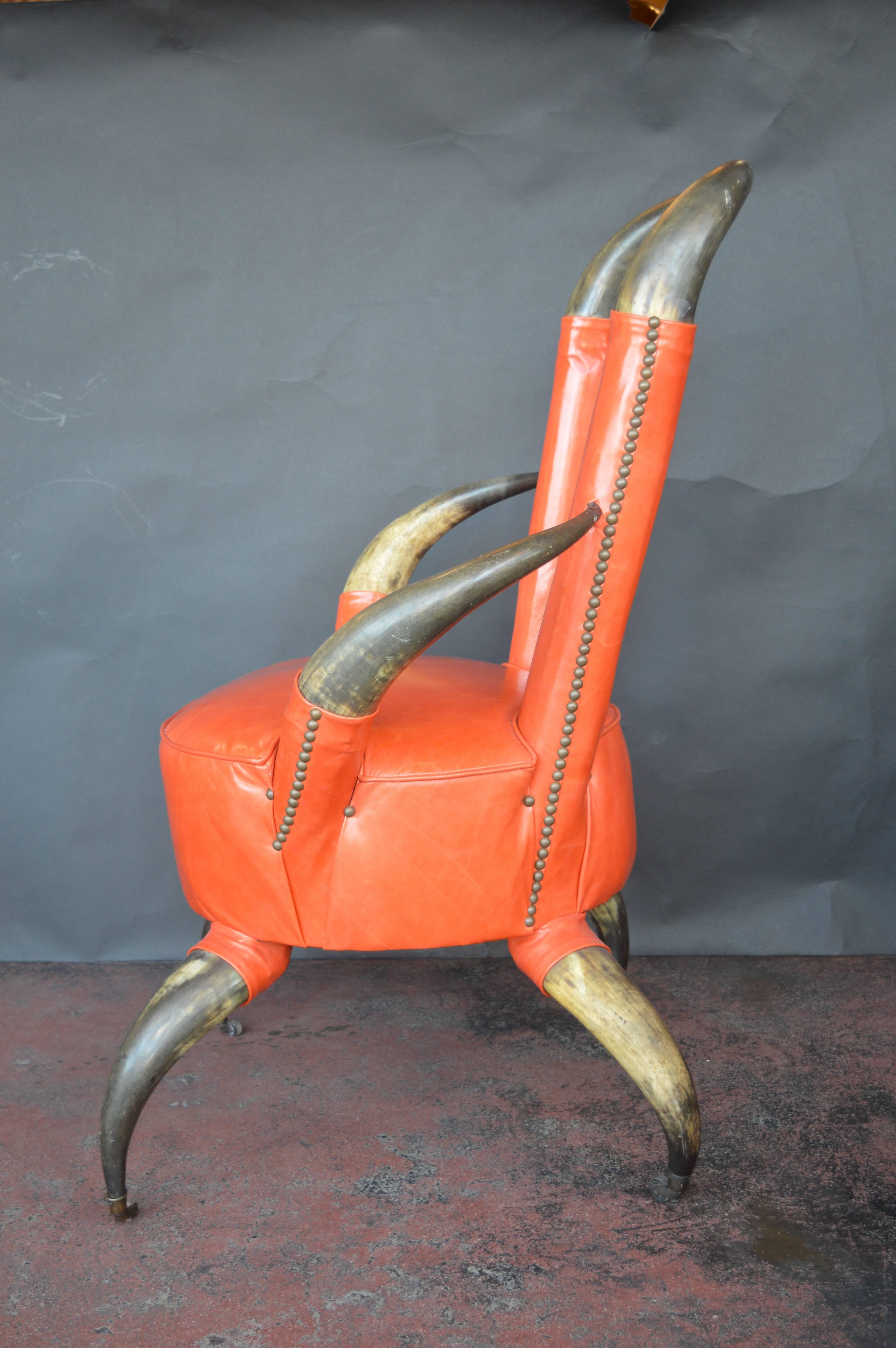 Cow horn chair in a burnt orange leather with matching ottoman. The ottoman measures 14