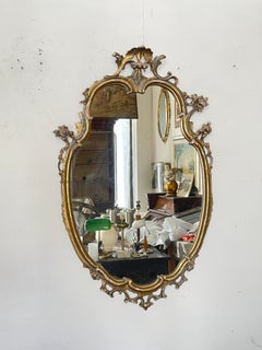 Wood and glass wall mirror with a carved gilded frame, 1970s