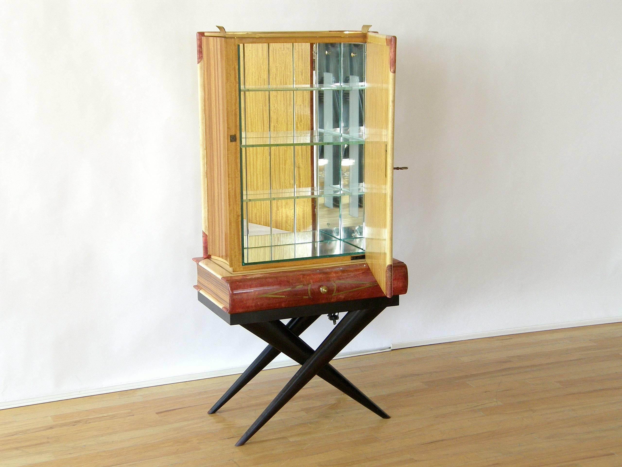 This trompe l'oeil bar by Aldo Tura is in the form of giant stacked books on a table. The top book stands up and has a door to conceal the bottles and glasses. The bottom book lies flat and the spine is a drawer to hold accessories like linens and