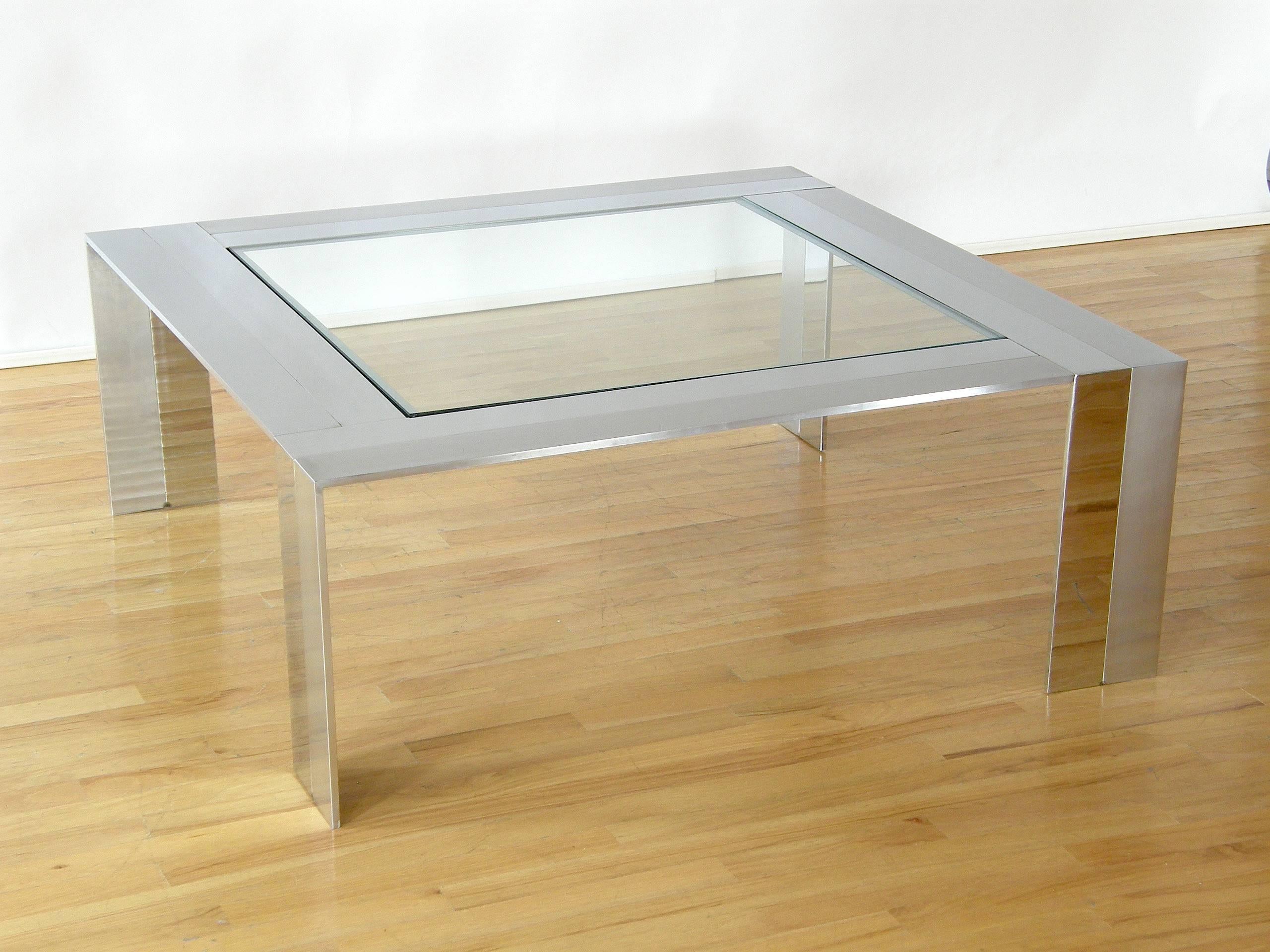 This Minimalist modern coffee or cocktail table has a very refined line. It is beautifully made of thick, polished and brushed stainless steel with clear evidence of the hand construction work involved in producing it.

We have seen this design
