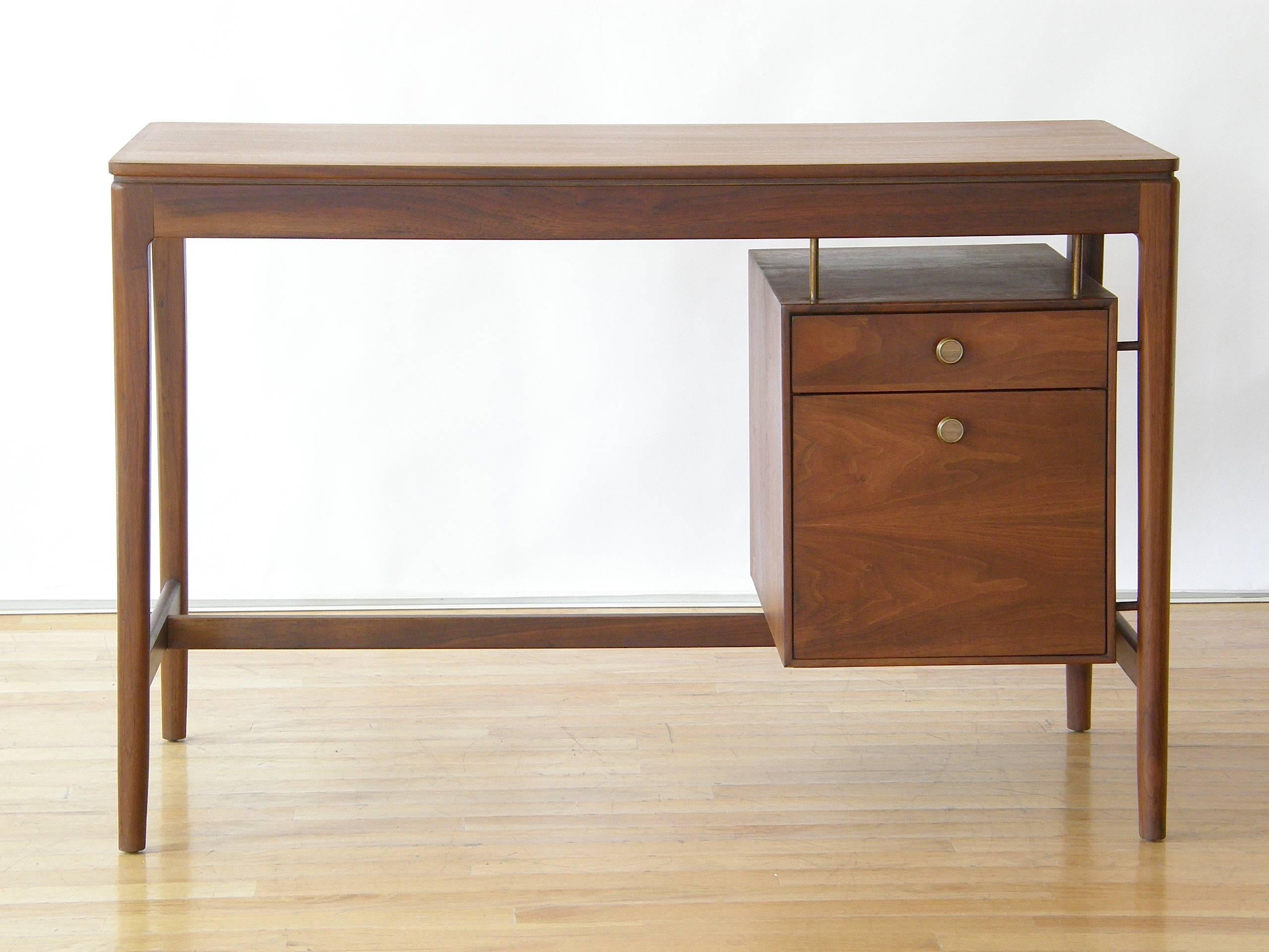 This walnut desk was designed by Stewart MacDougall and Kipp Stewart as part of the "Declaration" line for the Drexel furniture company. It features rounded corners on the top, a floating drawer box and a finished back. 

Please contact us