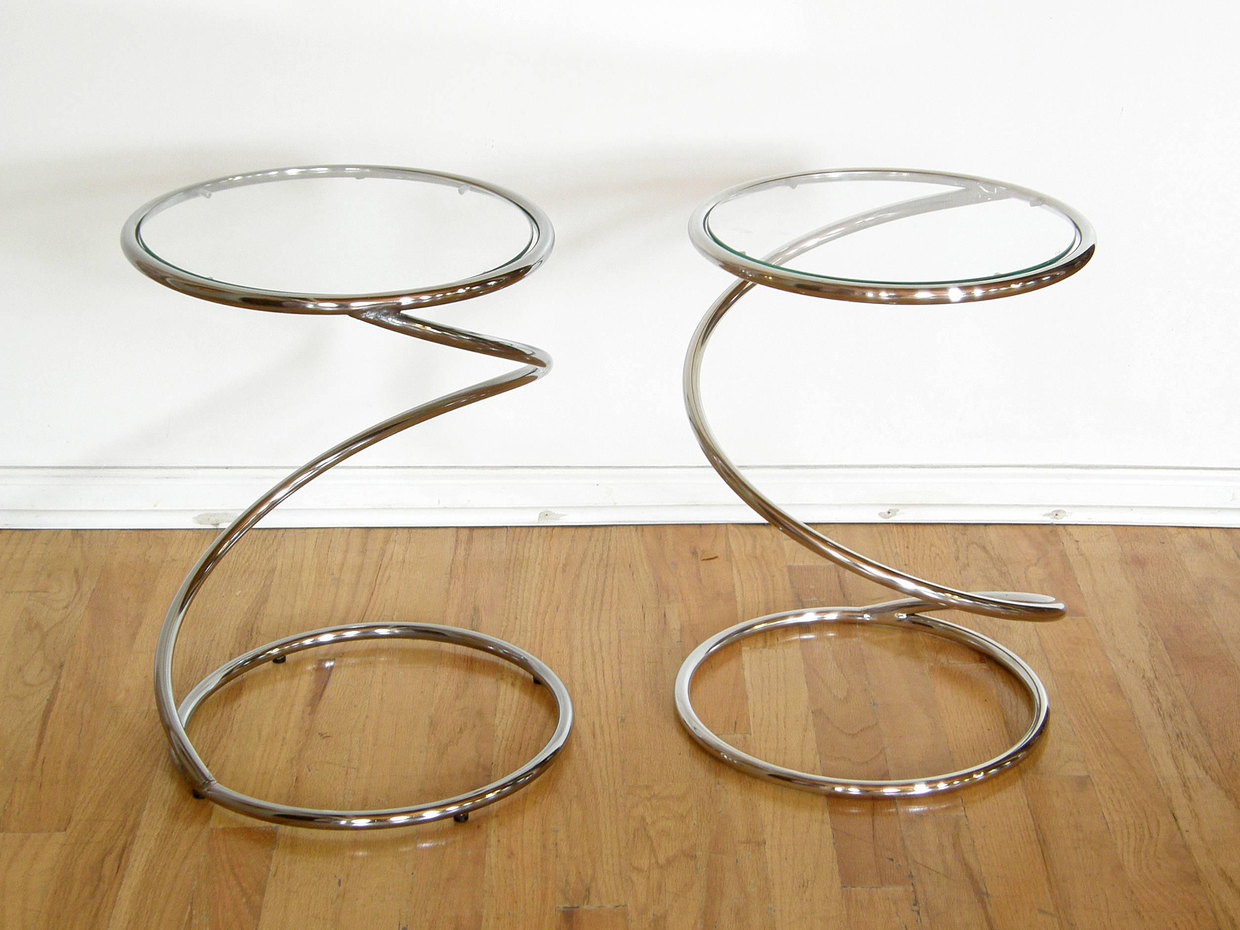 This whimsical pair of side tables have circular tops and bases with a spring or corkscrew shaped stem connecting them. They have a very animated quality, and they look a bit different from different angles.

Please note that though we bought these