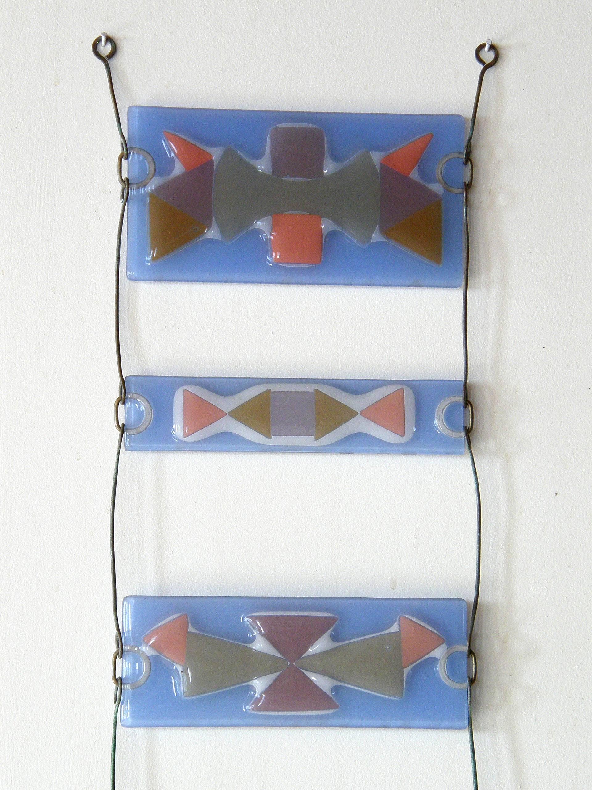 This colorful, fused glass wall pocket was made at the Higgins Glass Studio. It is likely one of Michael's designs since it utilizes pieces of colored glass arranged between sheets of other glass. Michael favored this technique which beautifully