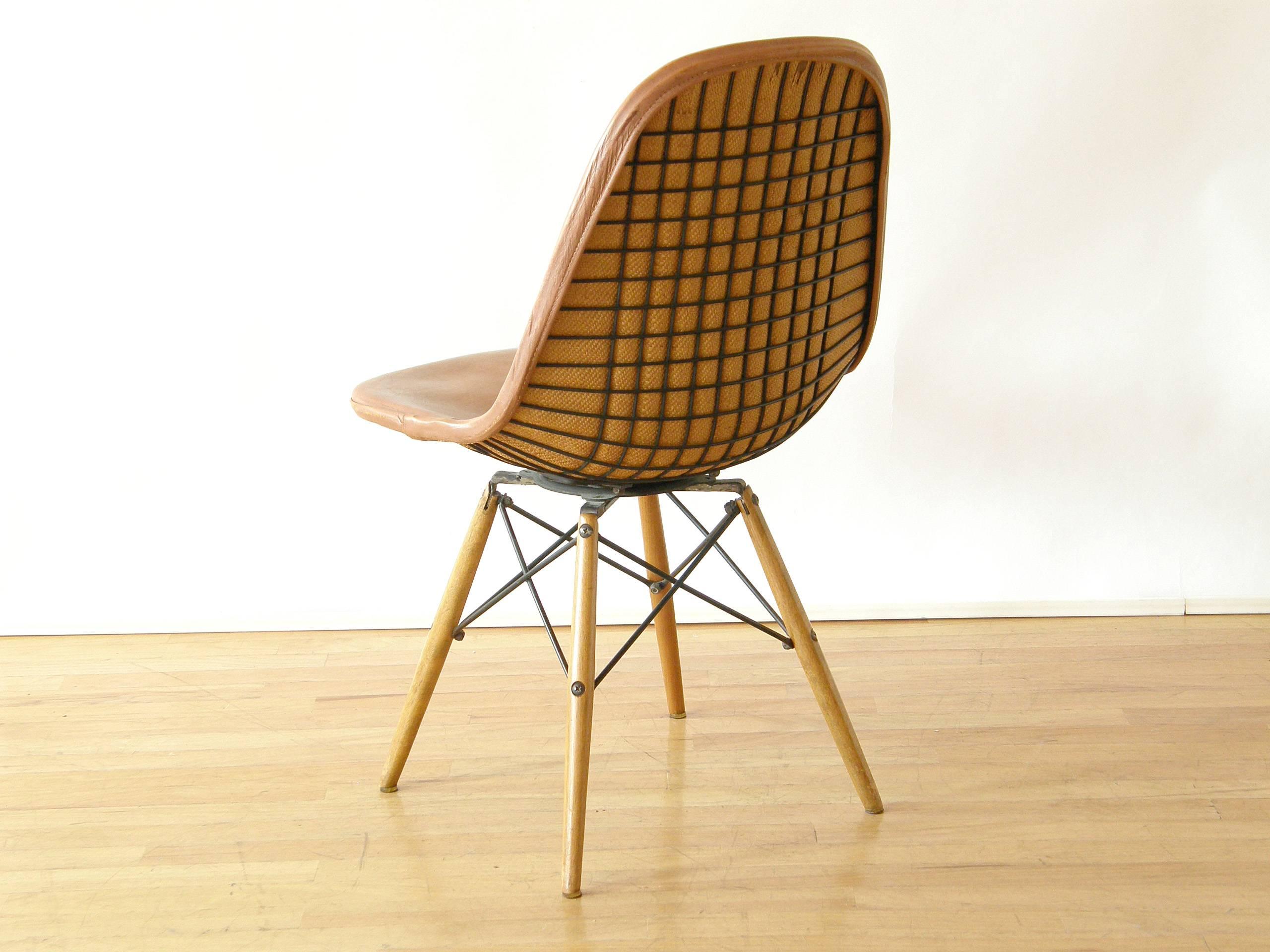 Swiveling, dowel leg chair with wire seat and original, burlap backed leather cover, designed by Charles and Ray Eames.

Please use 