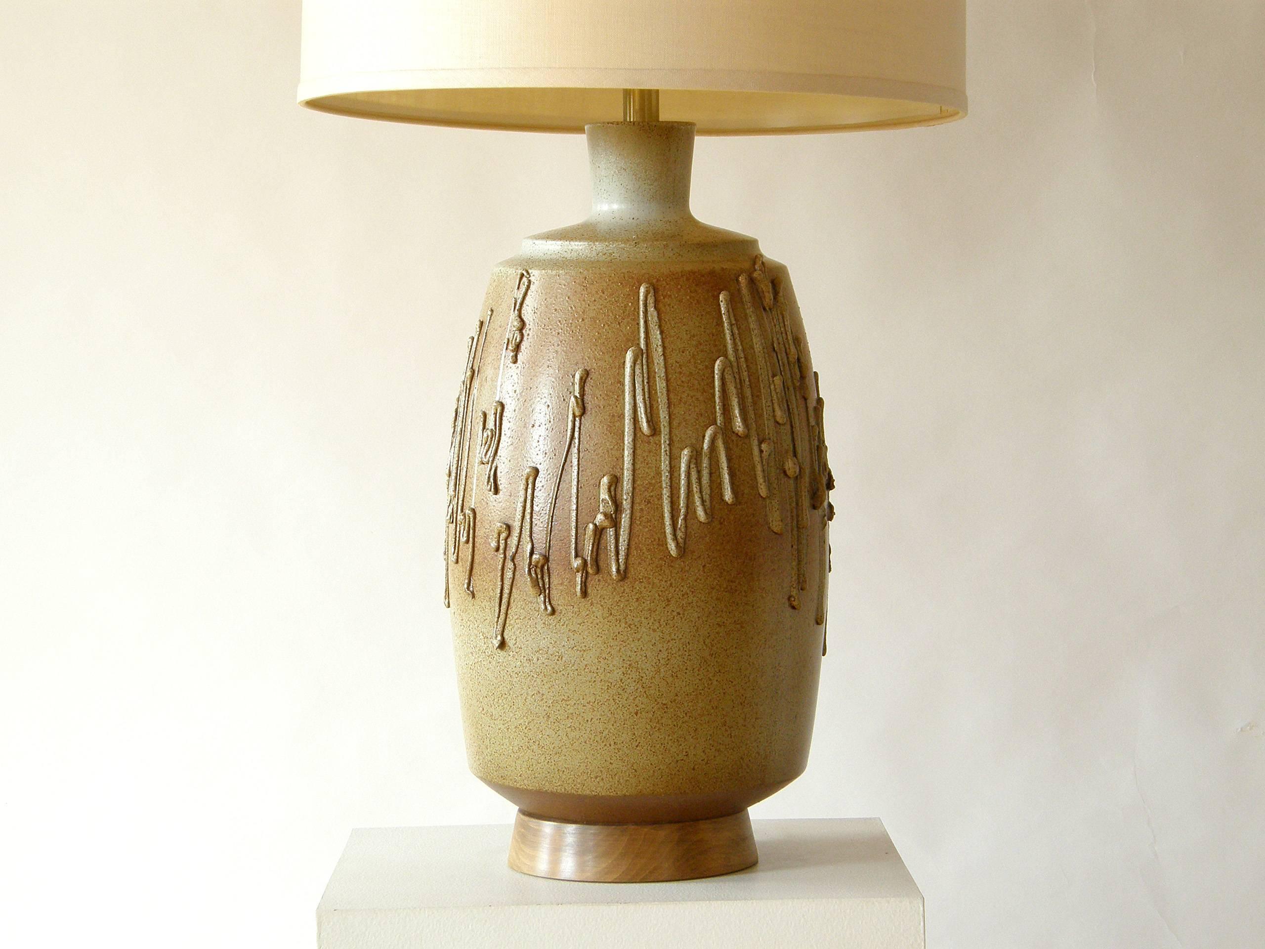 Lampe de table en céramique conçue par David Cressey pour Architectural Pottery. Il présente une glaçure brune mouchetée sur une couleur de base crémeuse et un traitement de surface texturé de gribouillis librement appliqués.

L'abat-jour illustré