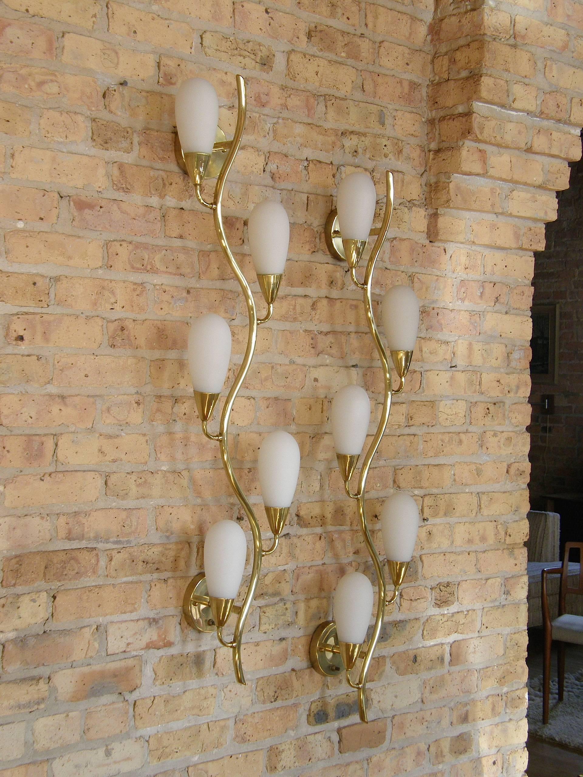 These sculptural brass, vine form wall sconces have undulating stems that branch off on alternating sides to hold pod shaped frosted glass lamp shades. The design is a wonderful combination of elegance and whimsy.

Lightbulbs will be included with