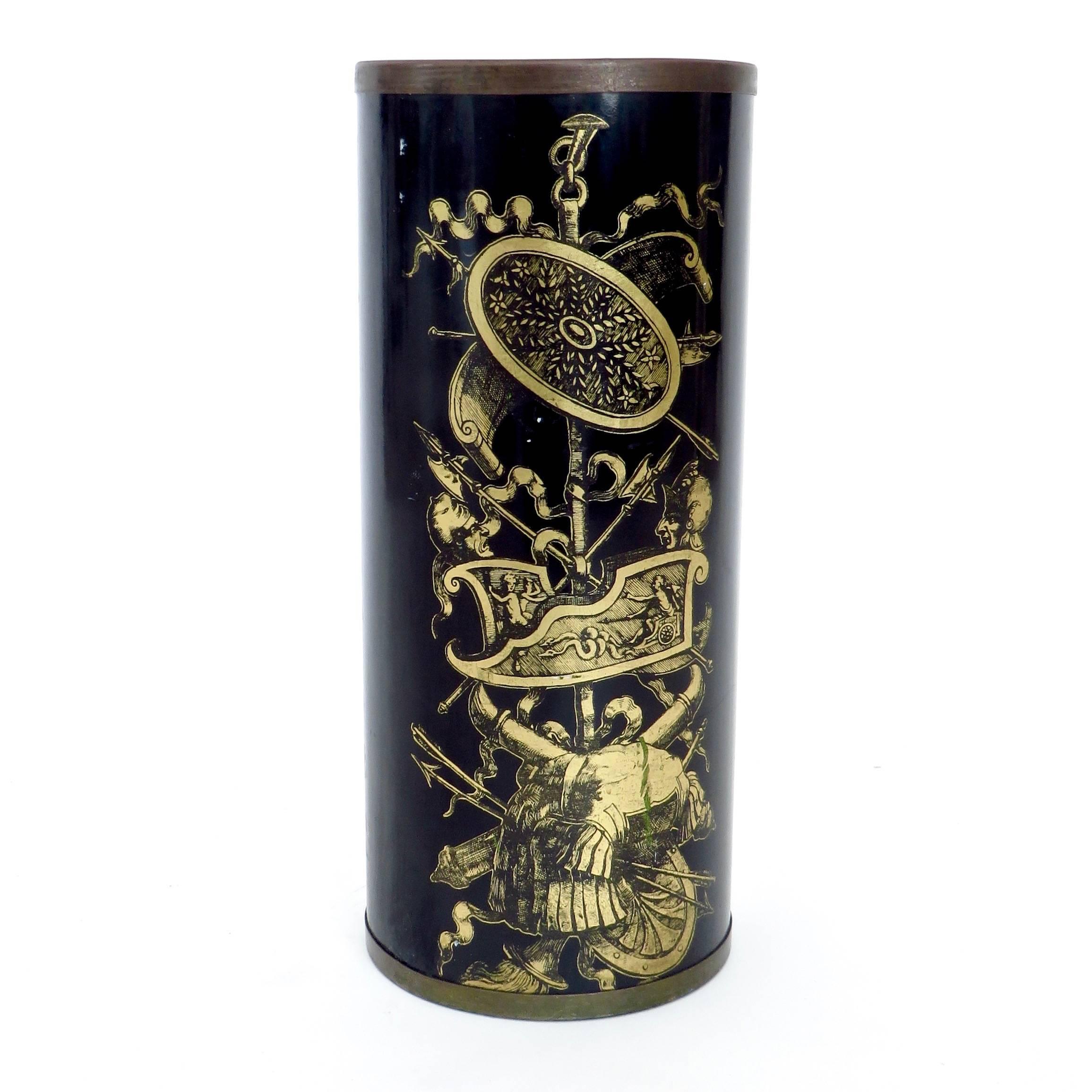 Italian umbrella stand/holder with historical events motif by Bucciarelli of Milan, circa 1950. Gold on black decoration with brass band on top and bottom.
Bucciarelli is often mistaken for Fornasetti. 
Label intact on bottom. Includes the bottom