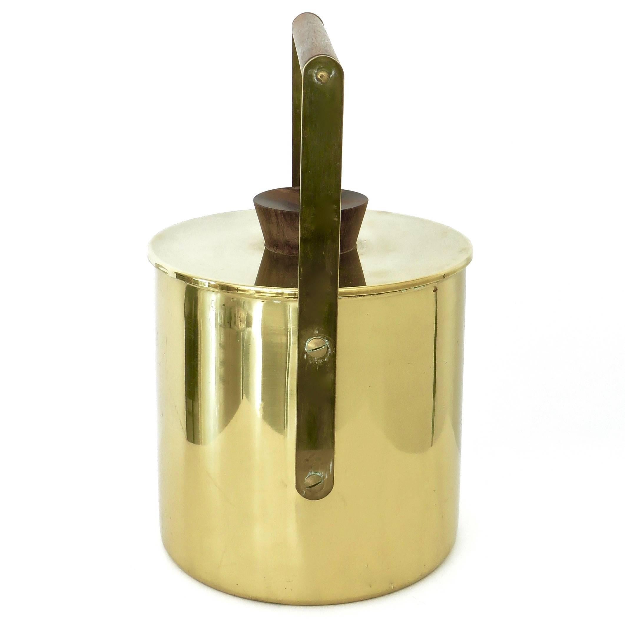 An Italian vintage modernist style polished brass ice bucket with white perfect condition liner and walnut handle and walnut pull top.
Stamped, made in Italy.
Maker unknown.