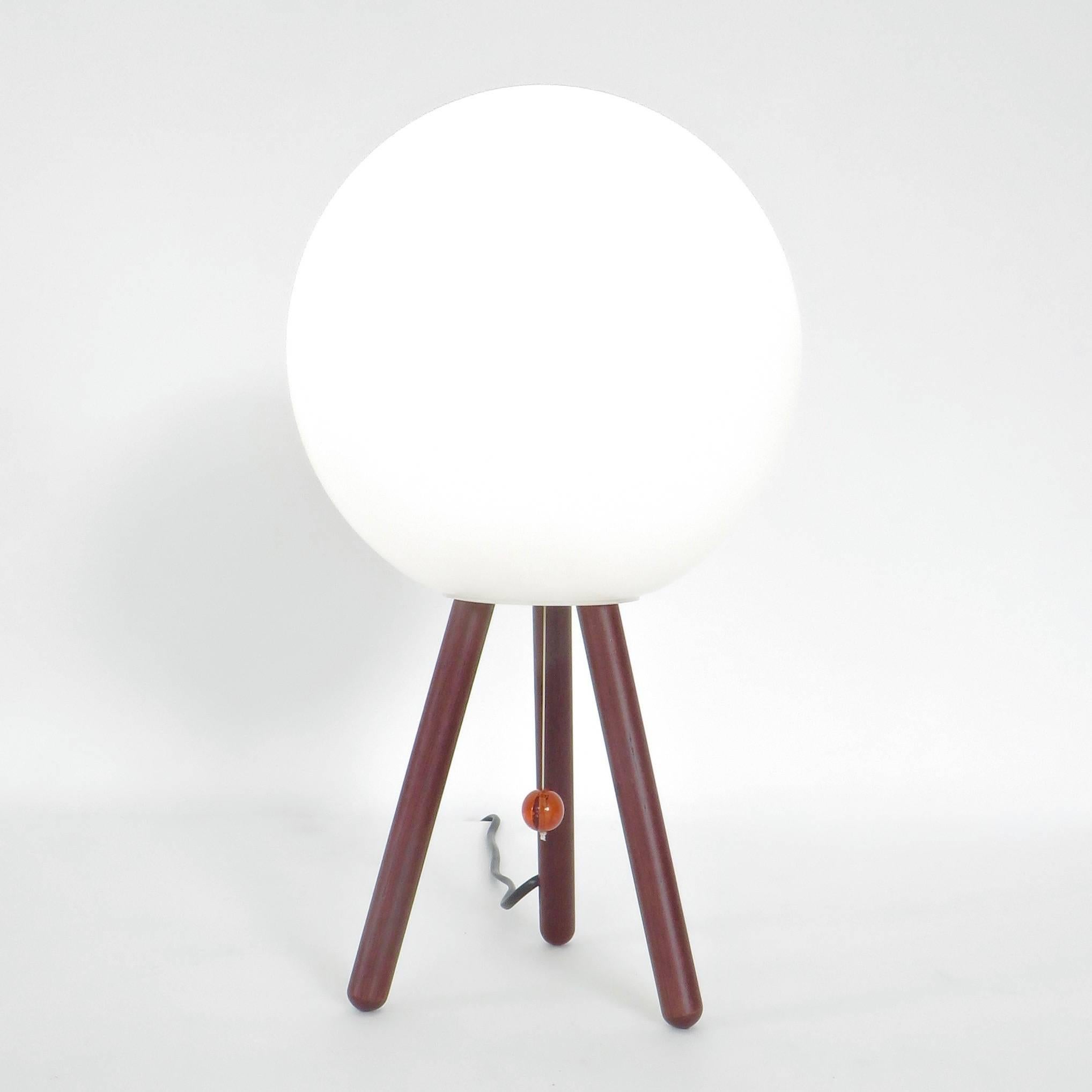 Daniela Pupa for Fontana Arte Piccola San table lamp with frosted glass shade on wood tripod base and an amber glass pull chain.
A minimalist and simple architectural table lamp.
Daniela Puppa came to the world of design through experimentation